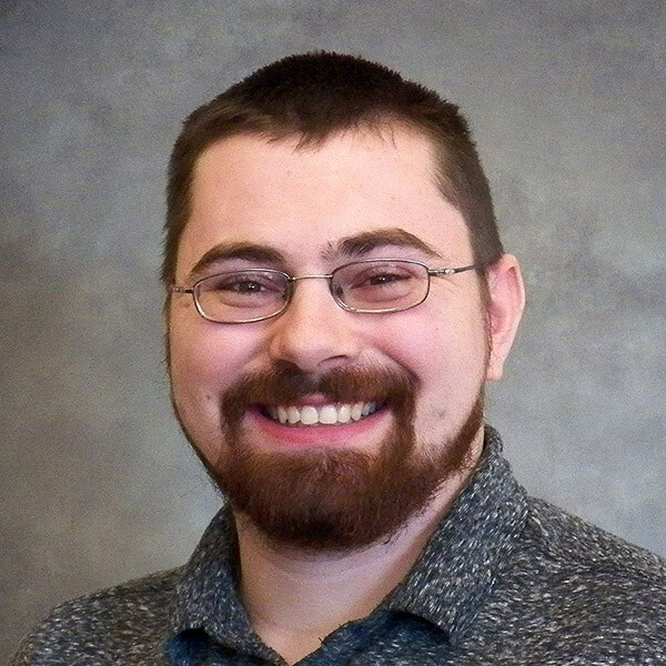 Smiling IT consultant with glasses and beard posing for professional headshot at Billings MT managed services company