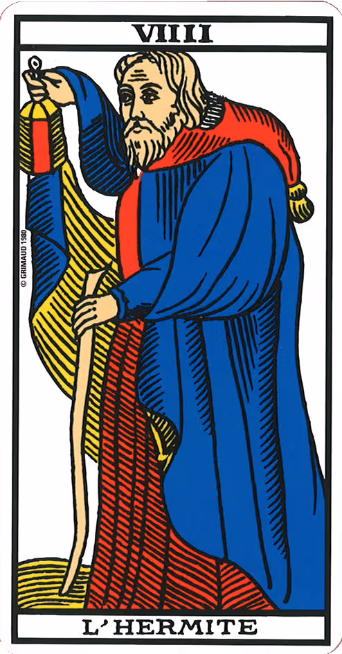 The Hermit tarot card, Rider deck: a cloaked old man looking down, also donning a big gray beard.
