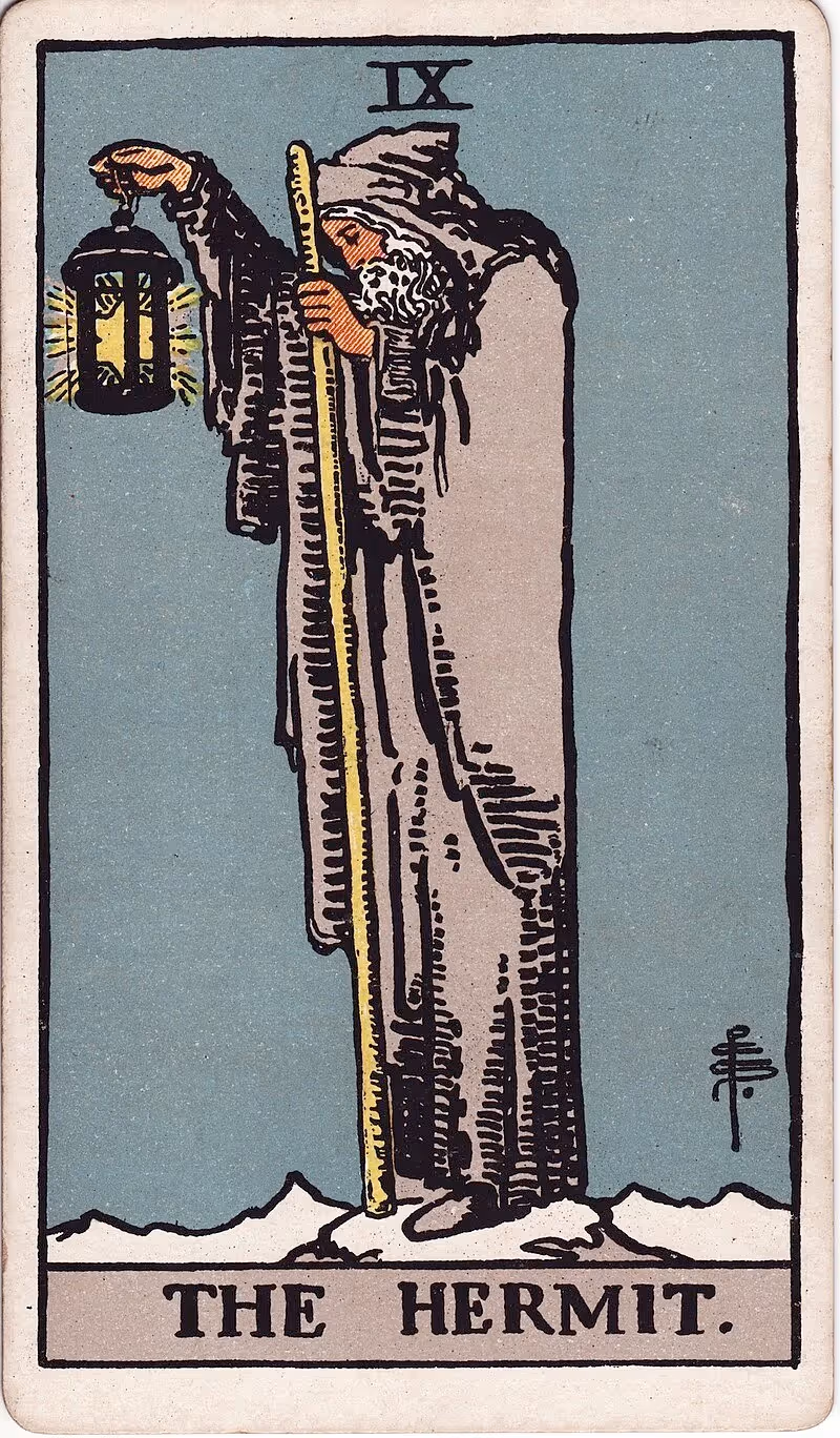 The Hermit tarot card, Rider deck: a cloaked old man looking down, also donning a big gray beard.