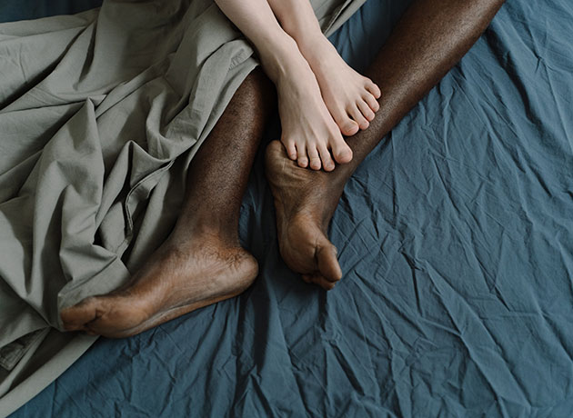 couple's feet entwined in bed