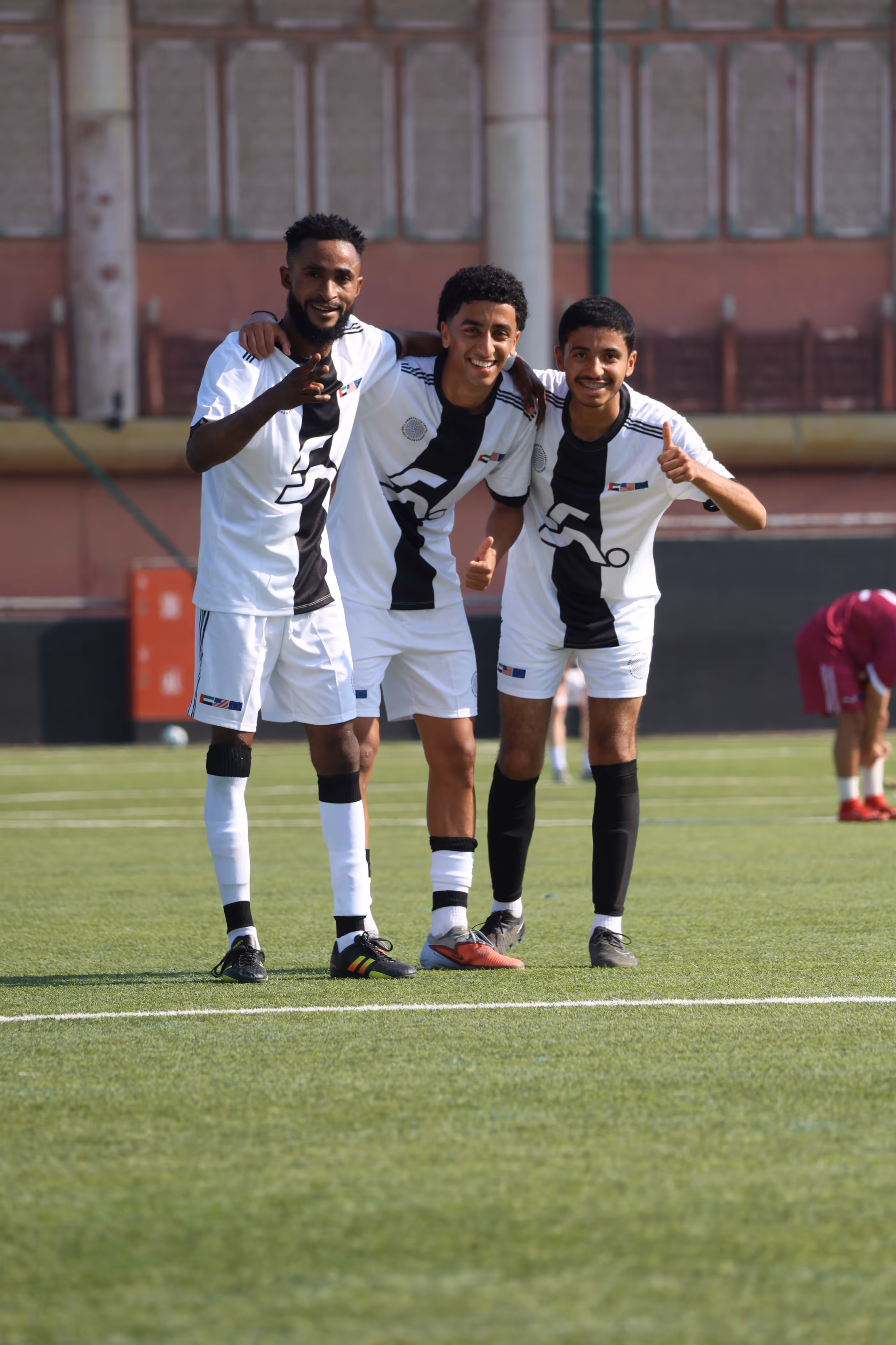 Man standing outside in sunlight wearing a gray shirt with 'Self Generation' text, clasping hands.