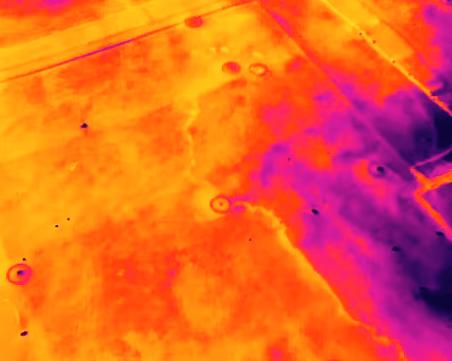 Thermal image showing warm and cool areas with circular and linear patterns on the surface.