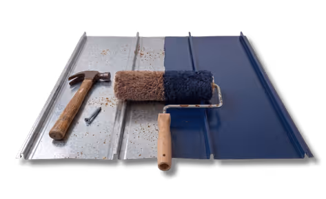 Paint roller covering metal sheet in blue paint beside a hammer and a nail on unpainted surface.