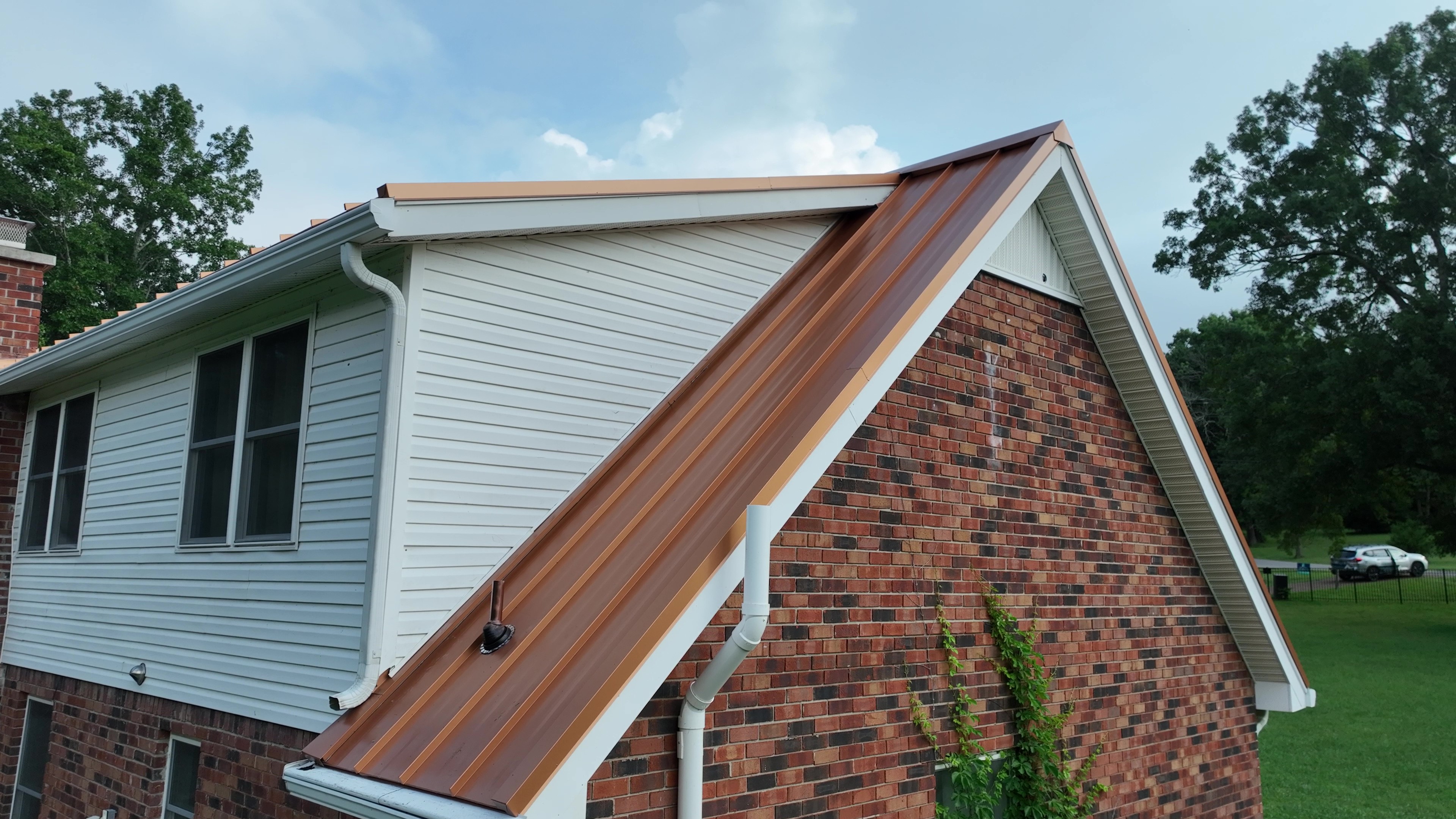 Copper penny standing seam metal roof and rake trim over a brick gable end in Lebanon, TN