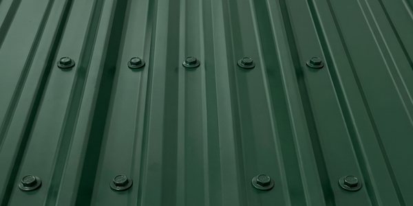 Green exposed fastener R-panel metal roof with visible screw lines