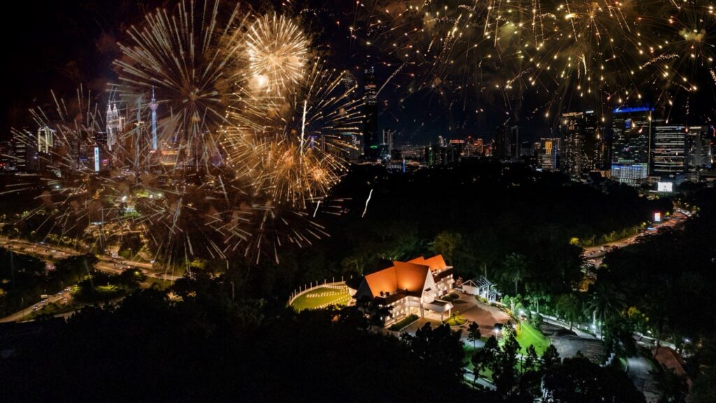 An aerial view of a spectacular fireworks display over the Kuala Lumpur skyline, celebrating a countdown event at Whitehouse @ The Estate on Federal Hill.