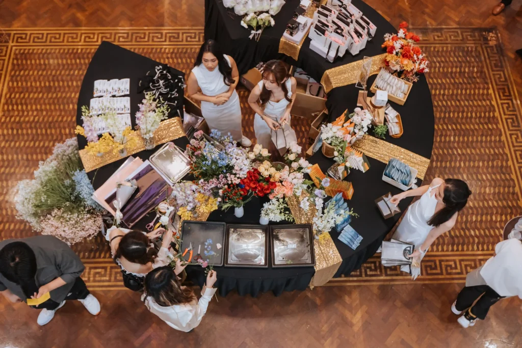 An overhead view of a creative workshop of nexting product launch in progress, with people gathered around tables decorated with flowers and products inside Whitehouse @ The Estate on Federal Hill.