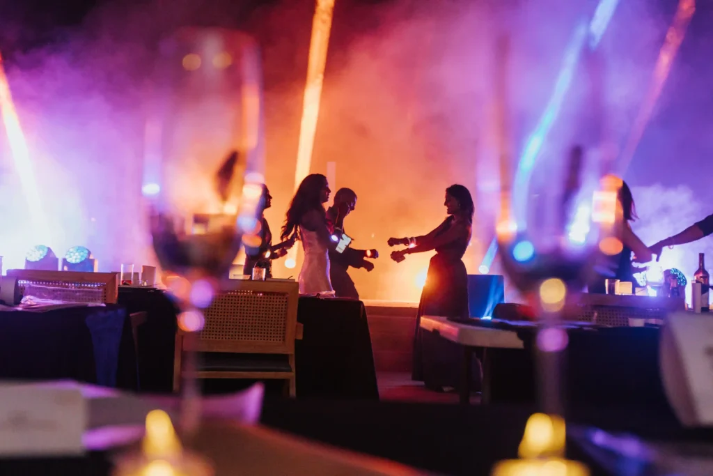 A lively party with guests dancing under dramatic spotlights at the LowKeyFete Countdown event at Whitehouse @ The Estate on Federal Hill.