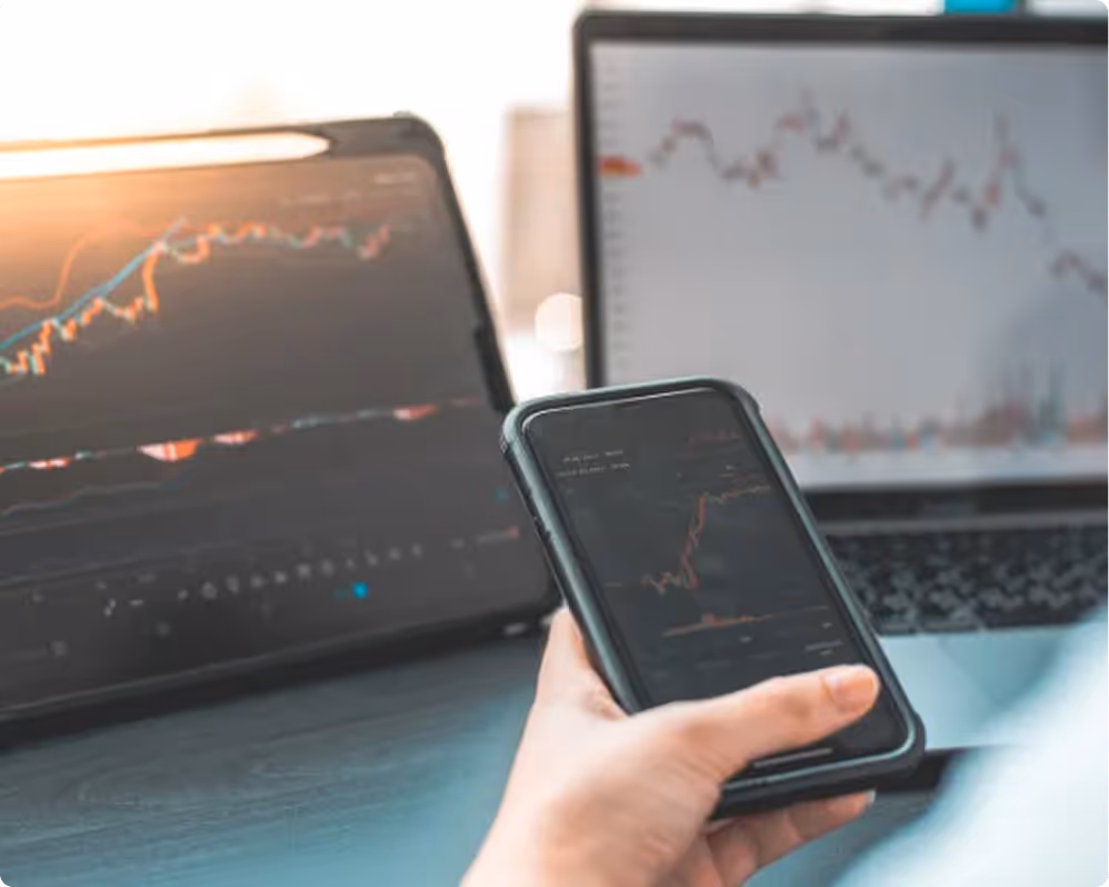 Personne tenant un smartphone affichant un graphique financier