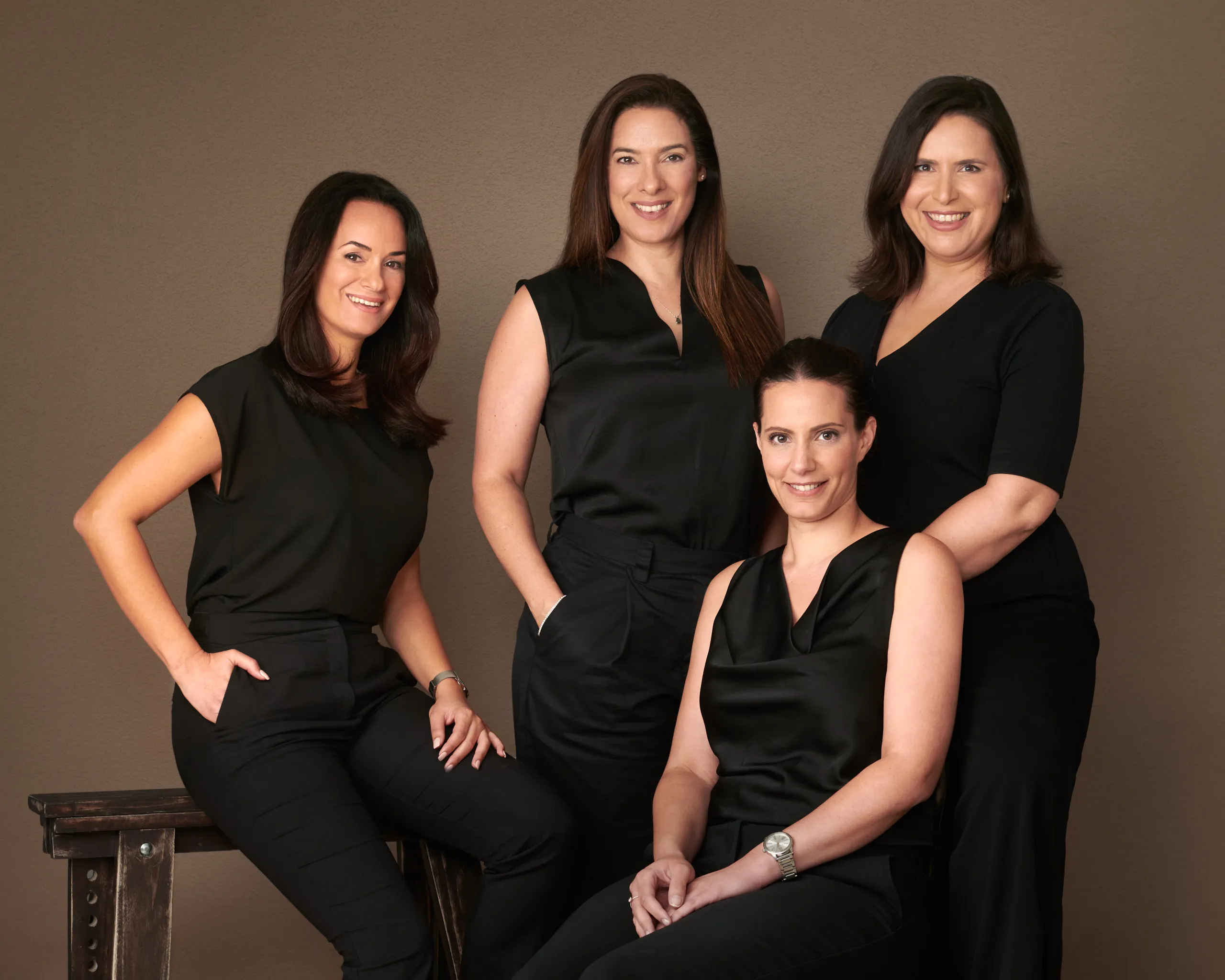 צילומי תדמית לצוות של ארבע עורכות דין בסטודיו, באווירה דינמית ומגובשת המדגישה שיתוף פעולה, תמונה קבוצתית המיועדת לאתר החברה.