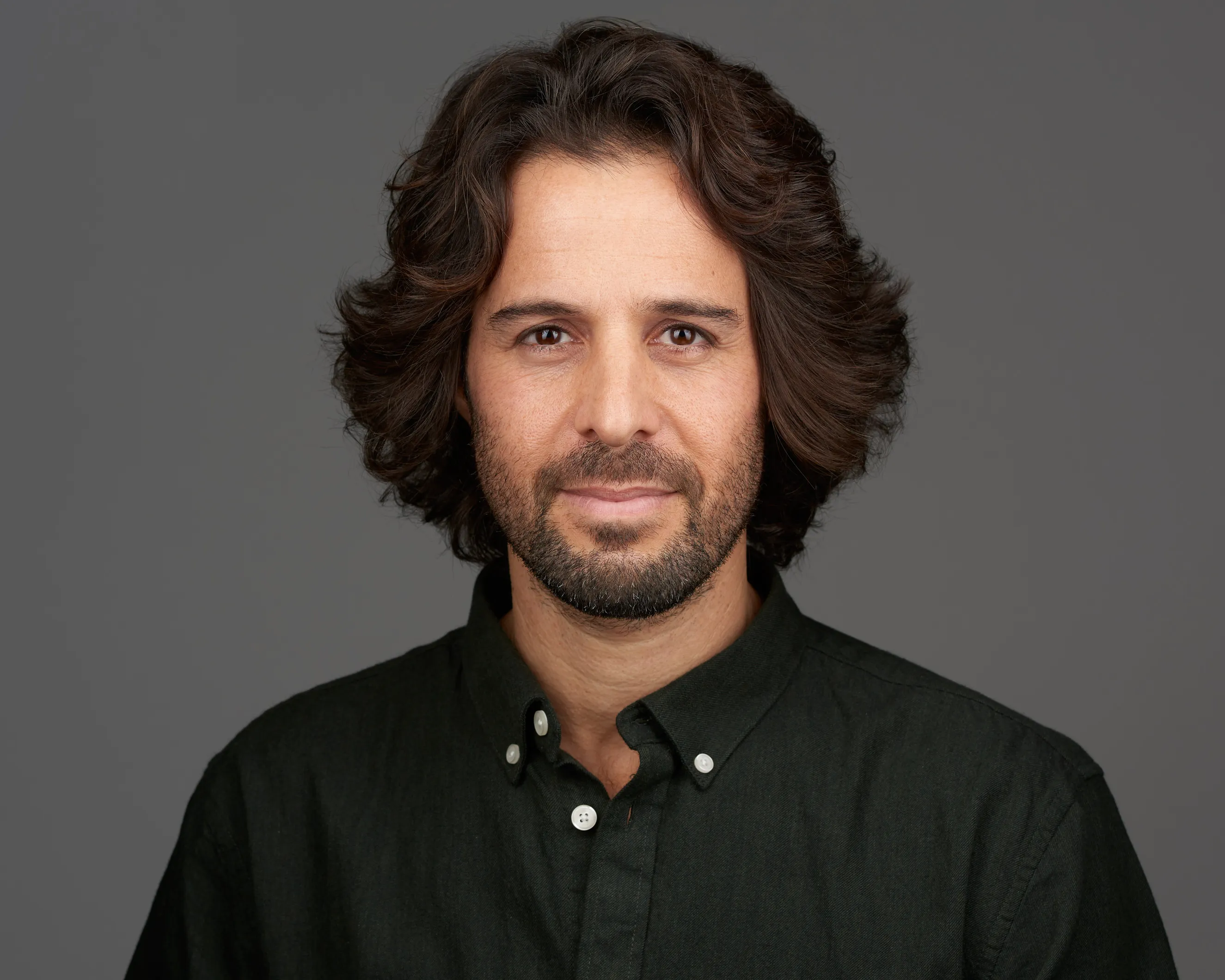 שותף עסקי בסטודיו. תדמית לעסקים במבט סמכותי ונינוח המשרה ביטחון. צילום תדמית מקצועי המיועד לאתר ולשימוש עסקי.