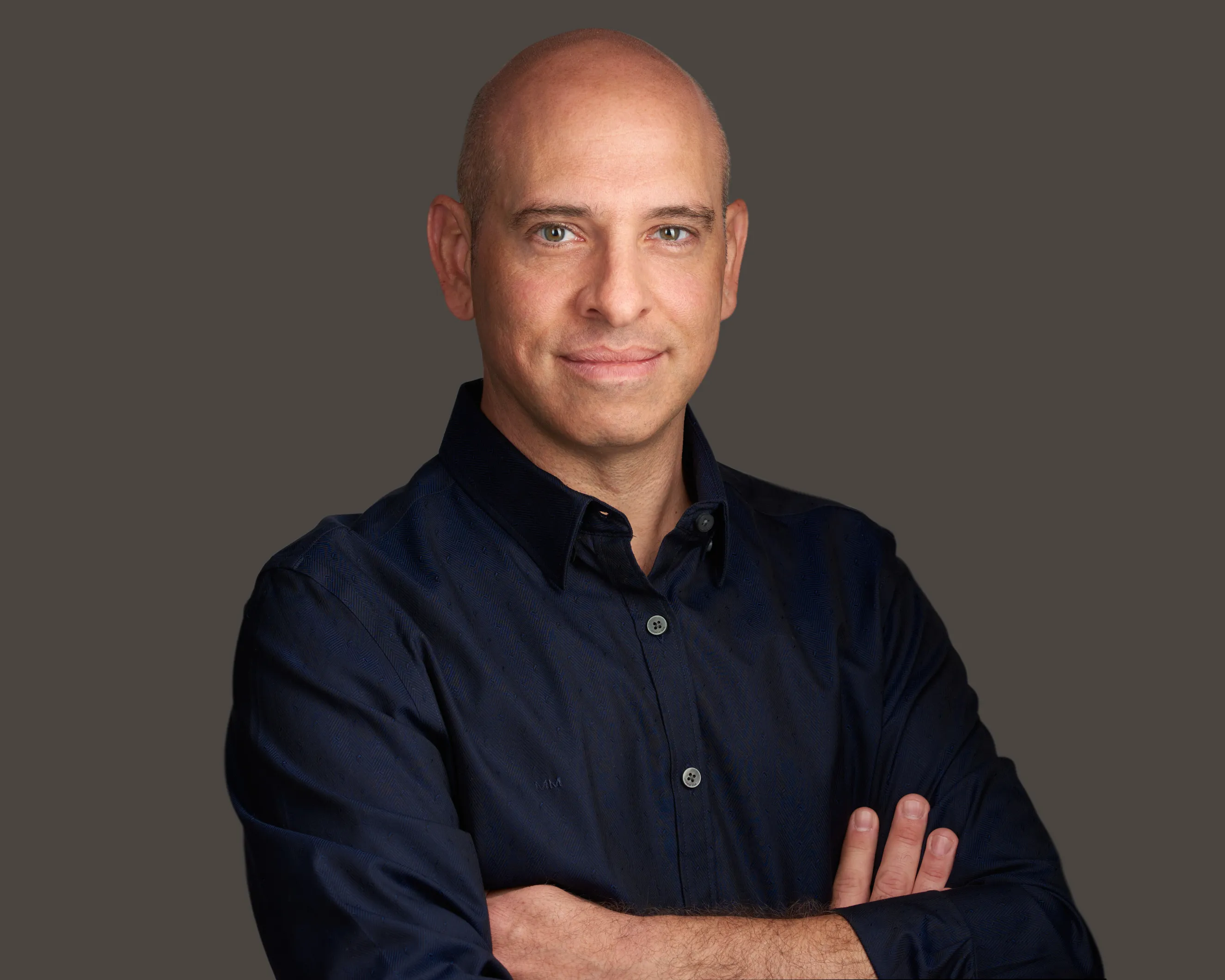 בעל עסק מהרצליה בסטודיו. צילום עסקים במבט סמכותי ונינוח המשרה ביטחון. צילום תדמית מקצועי המיועד לאתר ולשימוש עסקי.