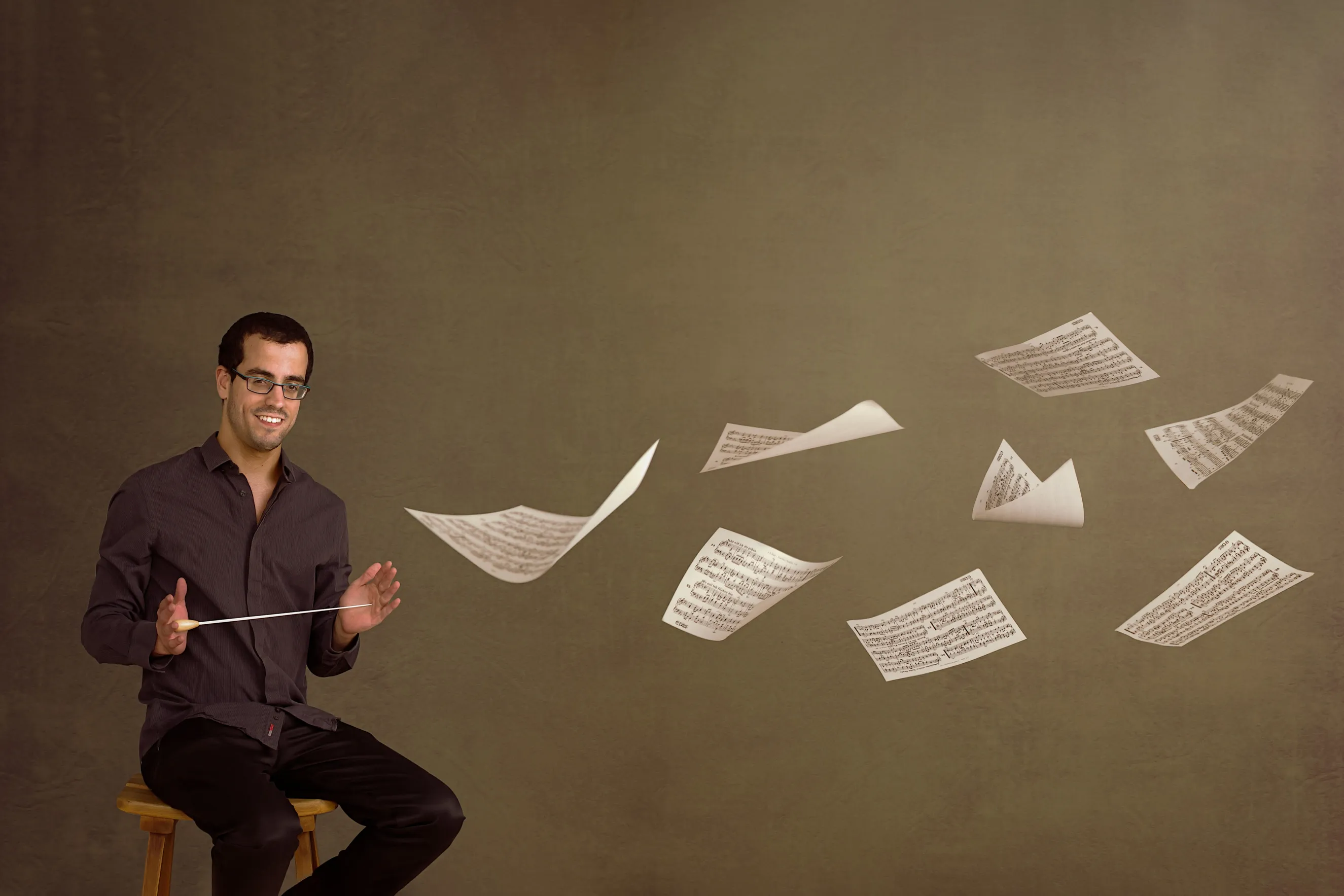 צילומי תדמית למוזיקאים כצילום קונספט אמנותי של מנצח צעיר, המדגיש את הזהות היצירתית והנוכחות הבימתית.