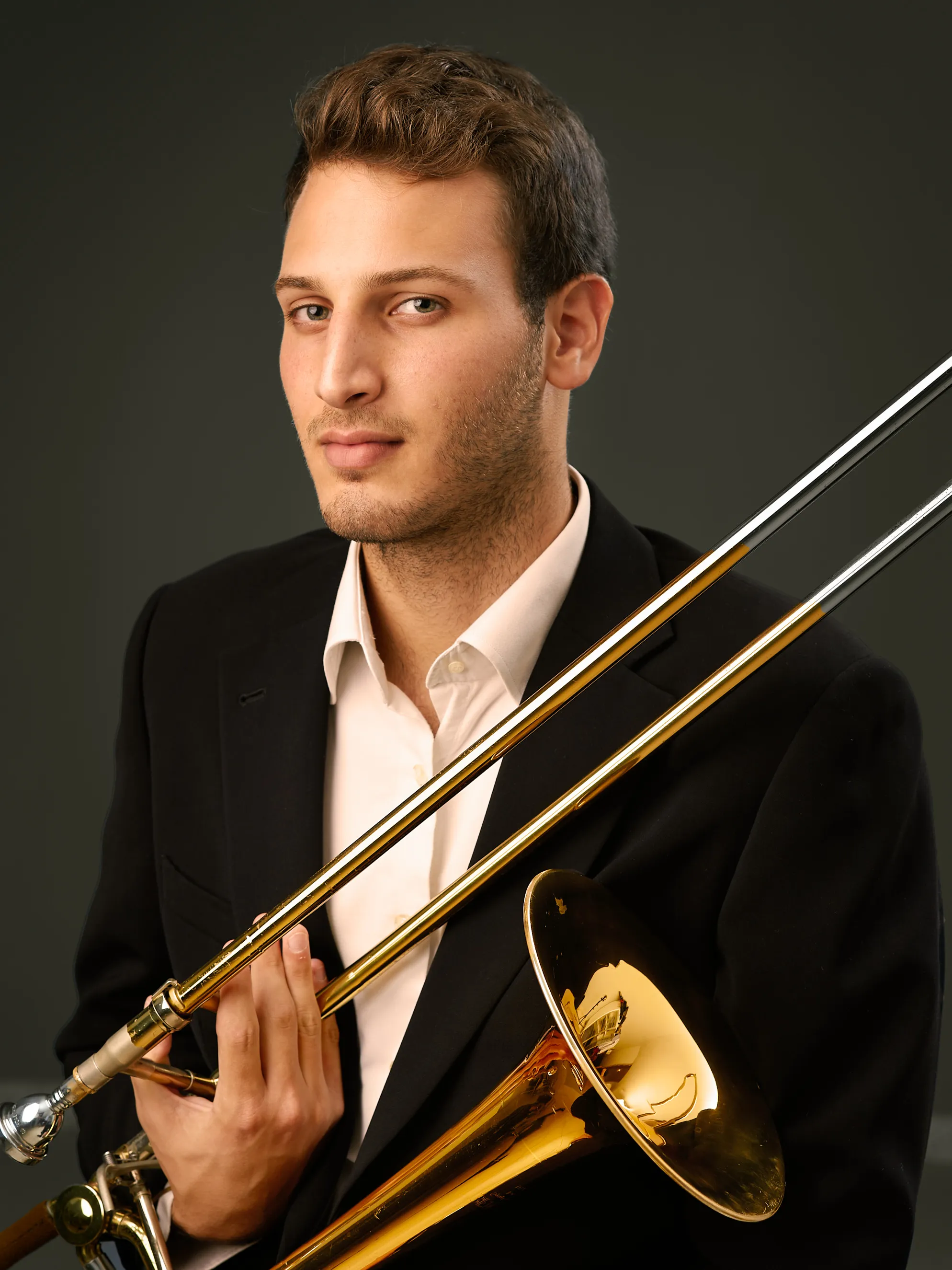תמונות תדמית למוזיקאים למיתוג ויזואלי של נגן טרומבון מגרמניה בסטודיו, בצילומי תדמית בפורטרט אמנותי מוקפד המדגיש את הזהות היצירתית.