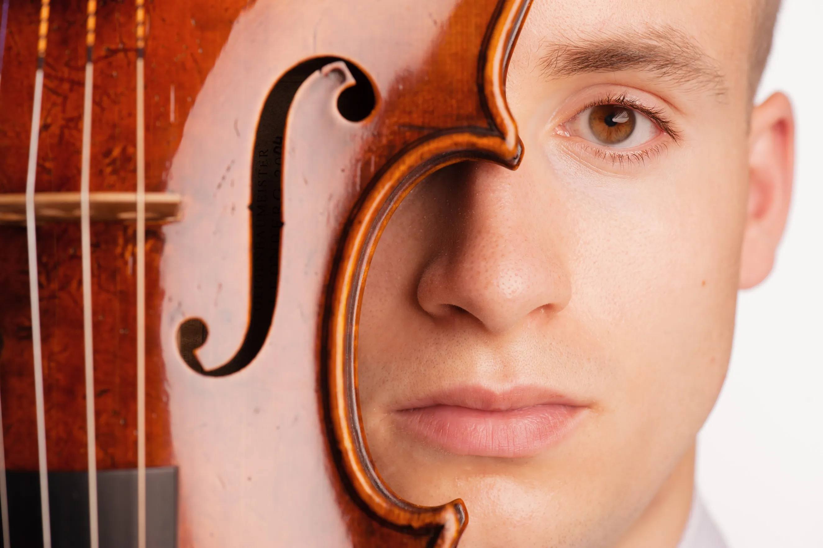 צילומי תדמית למוזיקאים המיועדים לאתר האמן של כנר מגרמניה בצילום קונספט בסטודיו, תחת תאורה דרמטית המשרה עומק יצירתי.