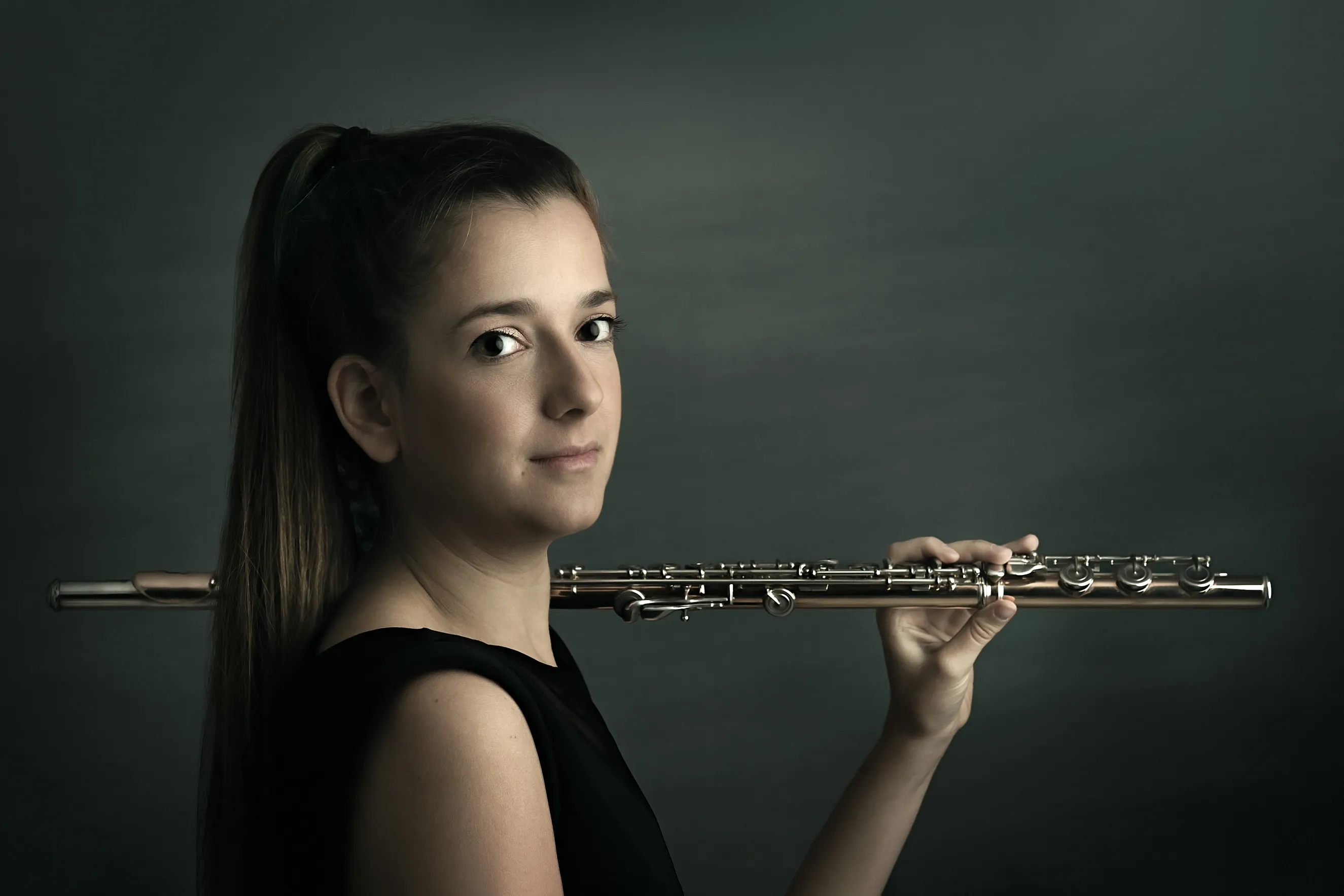 תמונות תדמית למוזיקאים למיתוג ויזואלי של נגנית חליל בסטודיו, בפורטרט מוזיקאי אמנותי מוקפד המדגיש את הזהות היצירתית.