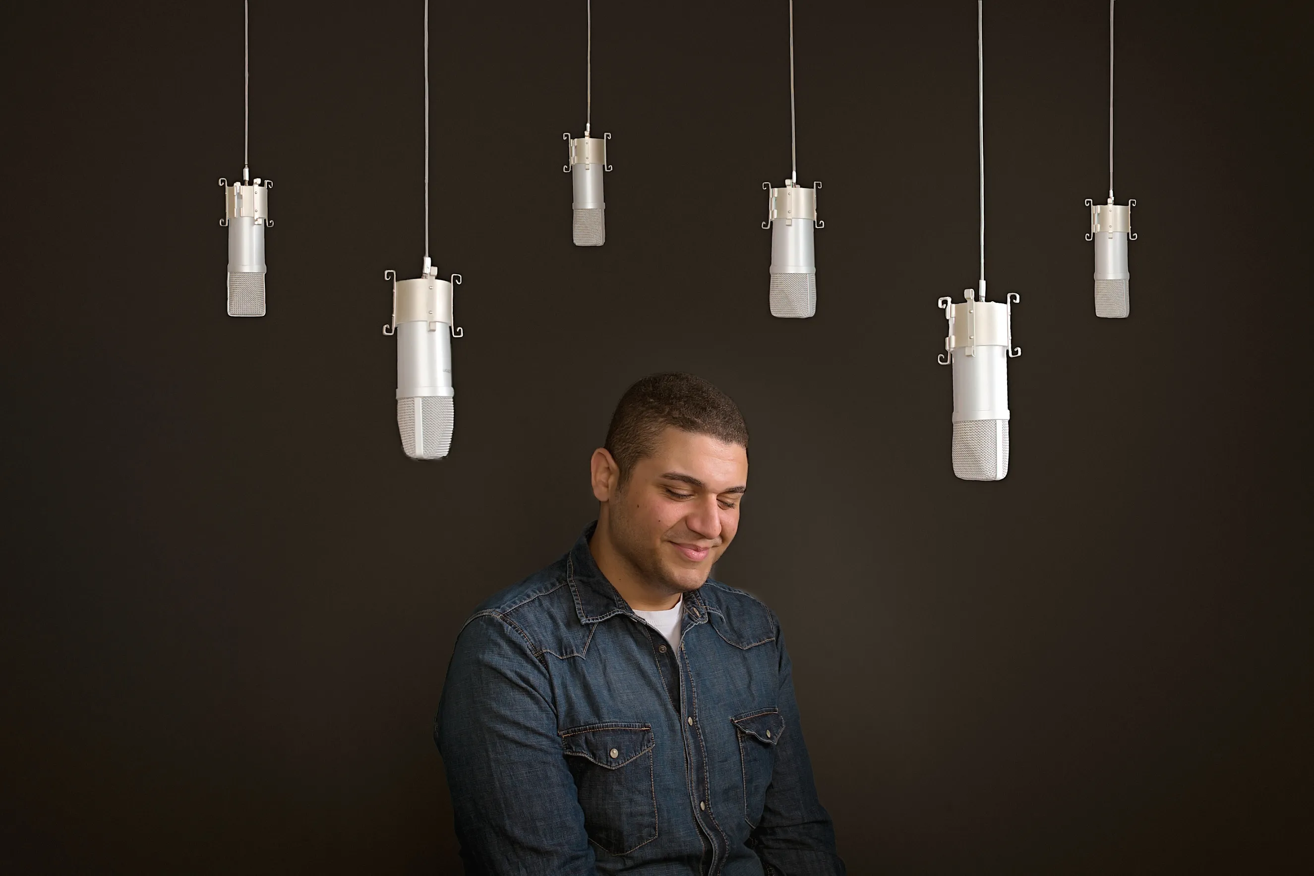 פורטרט מוזיקאי איכותי לשימוש מקצועי ופרסום של זמר מראש העין בצילום קונספט בסטודיו, במבט מלא ריכוז ותשוקה מוזיקלית.