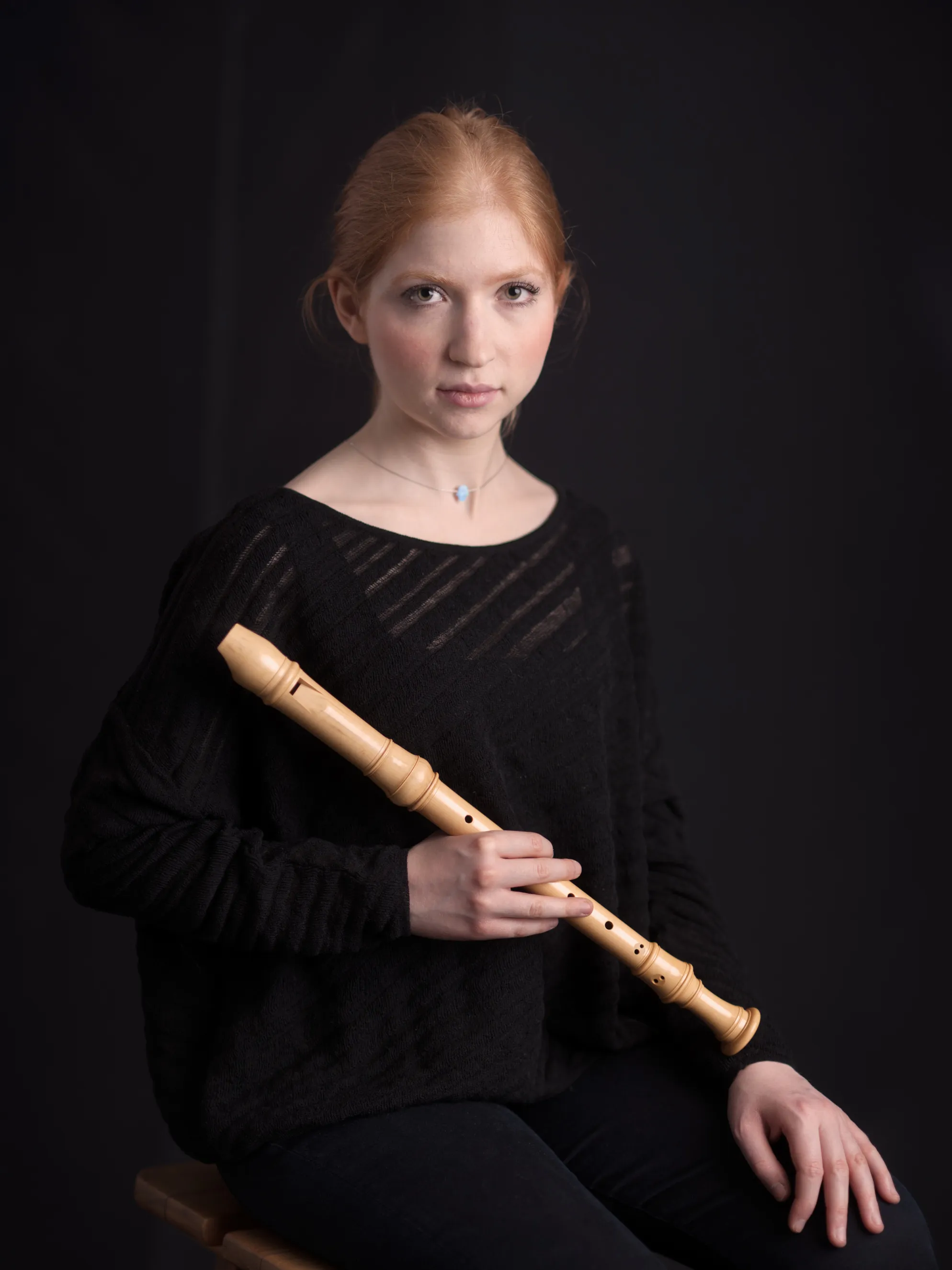 צילומי תדמית למוזיקאים המיועדים לאתר האמן של מוזיקאי מגרמניה בסטודיו, תחת תאורה דרמטית המשרה עומק יצירתי.