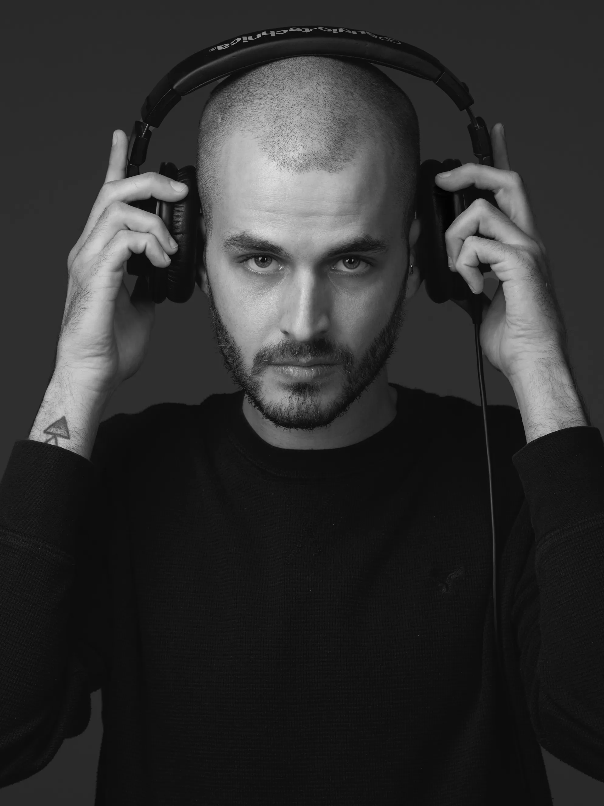 פורטרט מוזיקאי איכותי לשימוש מקצועי ופרסום של גיטריסט מרעננה בסטודיו, במבט מלא ריכוז ותשוקה מוזיקלית.