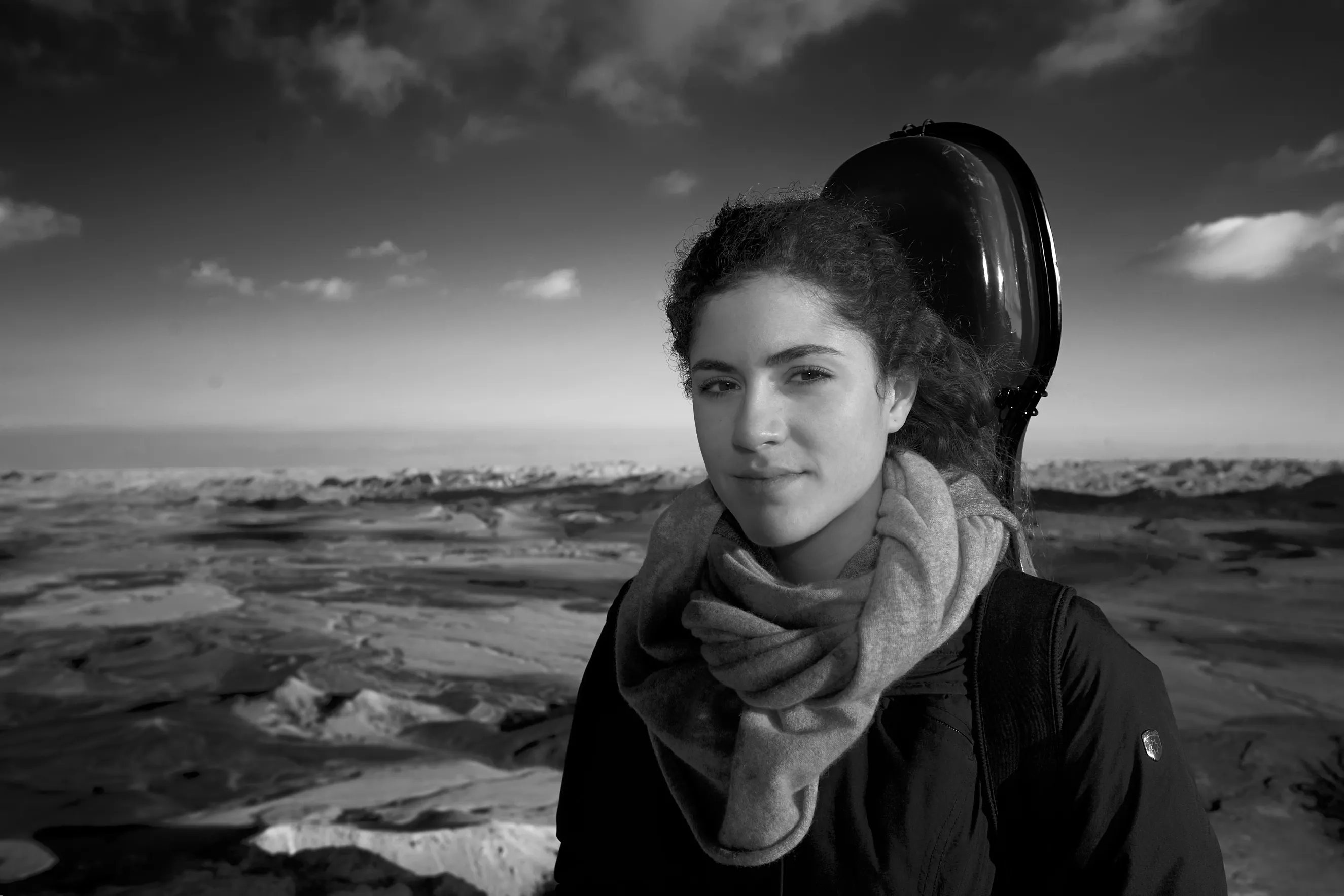 צילום מוזיקאים מקצועי ליחסי ציבור של צ'לנית בלוקיישן במצפה רמון, באווירה אמנותית המדגישה את הקשר לכלי הנגינה.