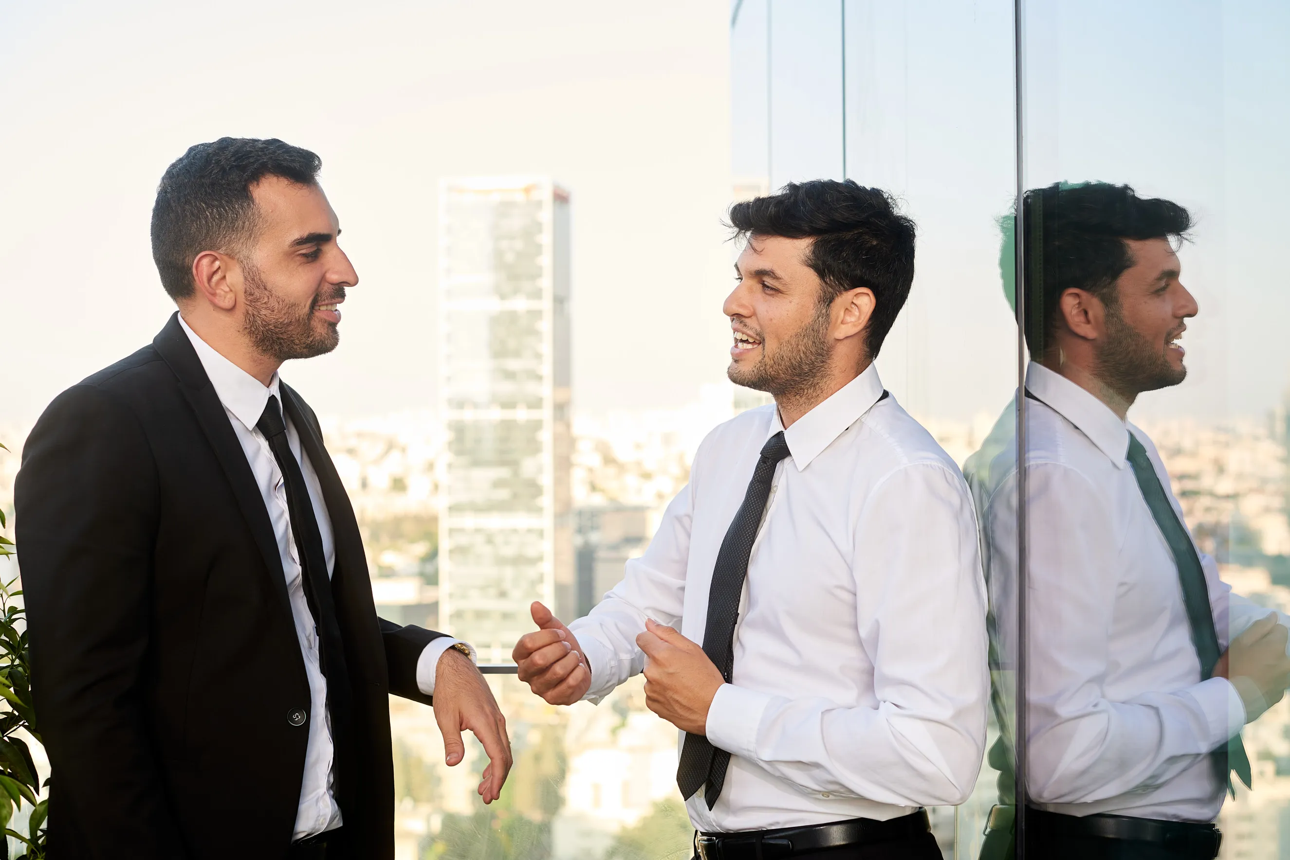 צילומי תדמית לשני עורכי דין בשיח מקצועי במשרד בתל אביב, בסביבת עבודה מודרנית ובאווירה מוארת המשרות אמינות ויוקרה.