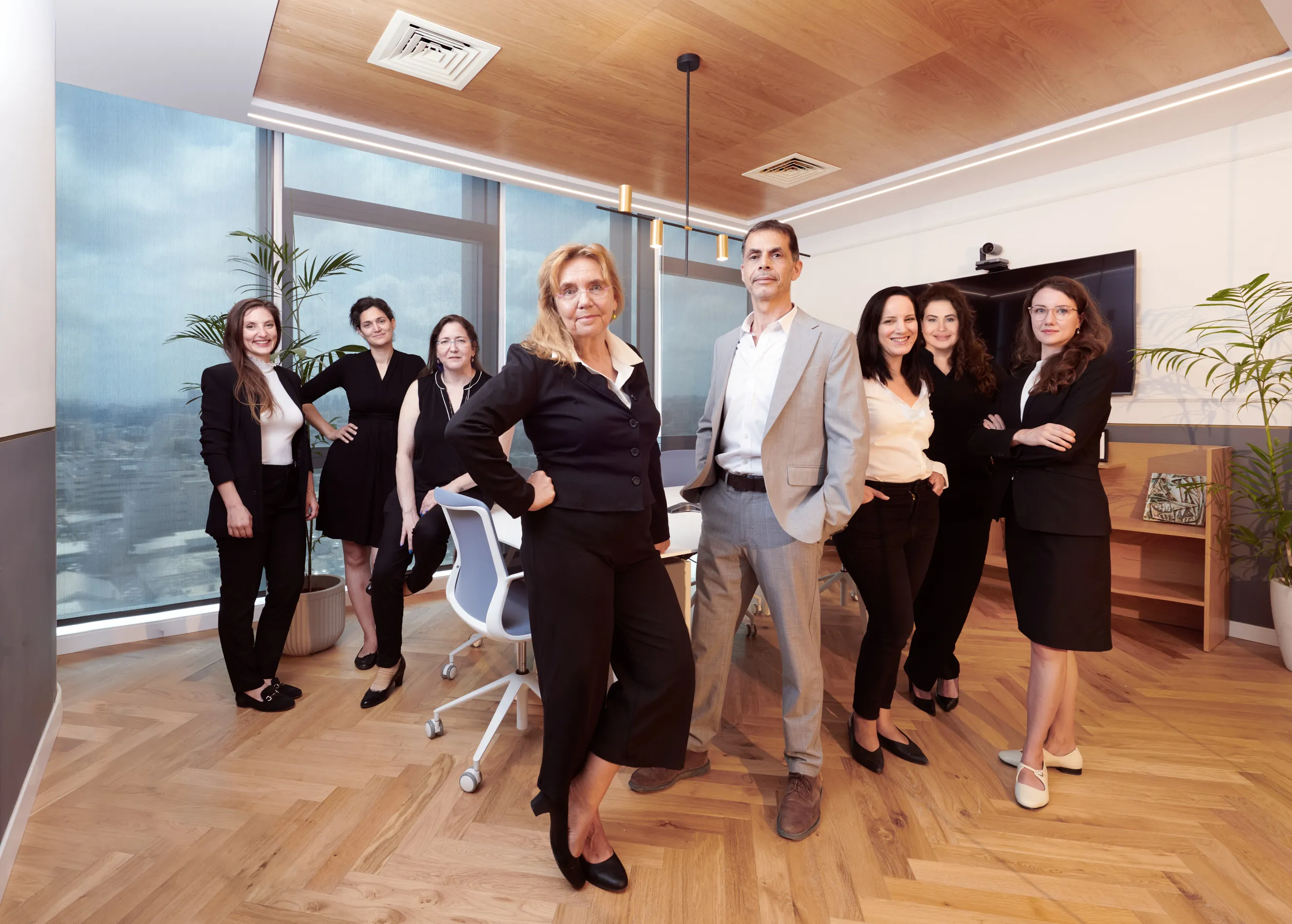 צילומי תדמית לנבחרת משפטית בחדר ישיבות בבני ברק: תמונה קבוצתית באווירה דינמית ומגובשת המדגישה שיתוף פעולה, עבור אתר החברה.