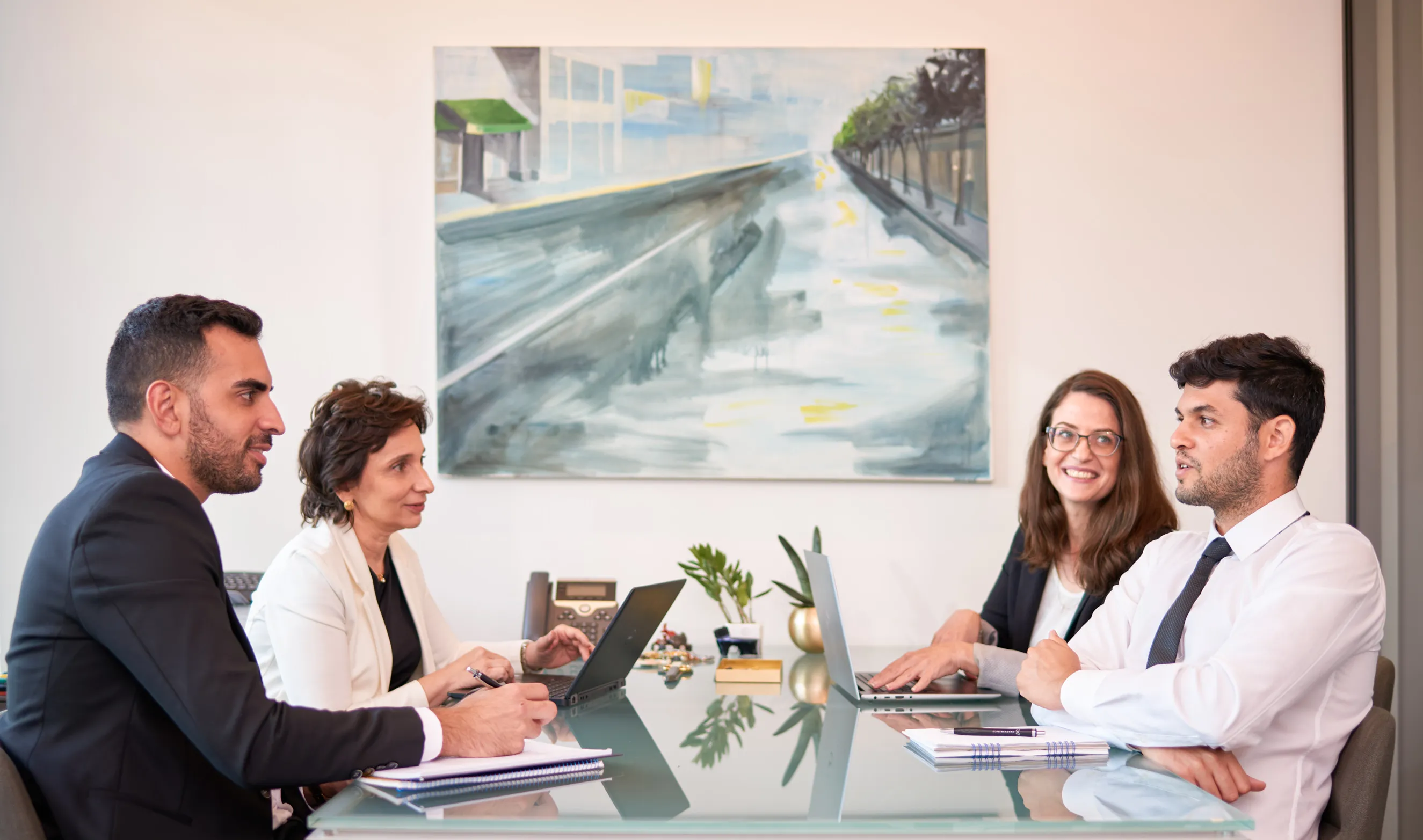 צילום משרד עורכי דין עבור אתר המשרד והלינקדאין של צוות משפטי של ארבעה עורכי דין בשיח מקצועי בחדר ישיבות.