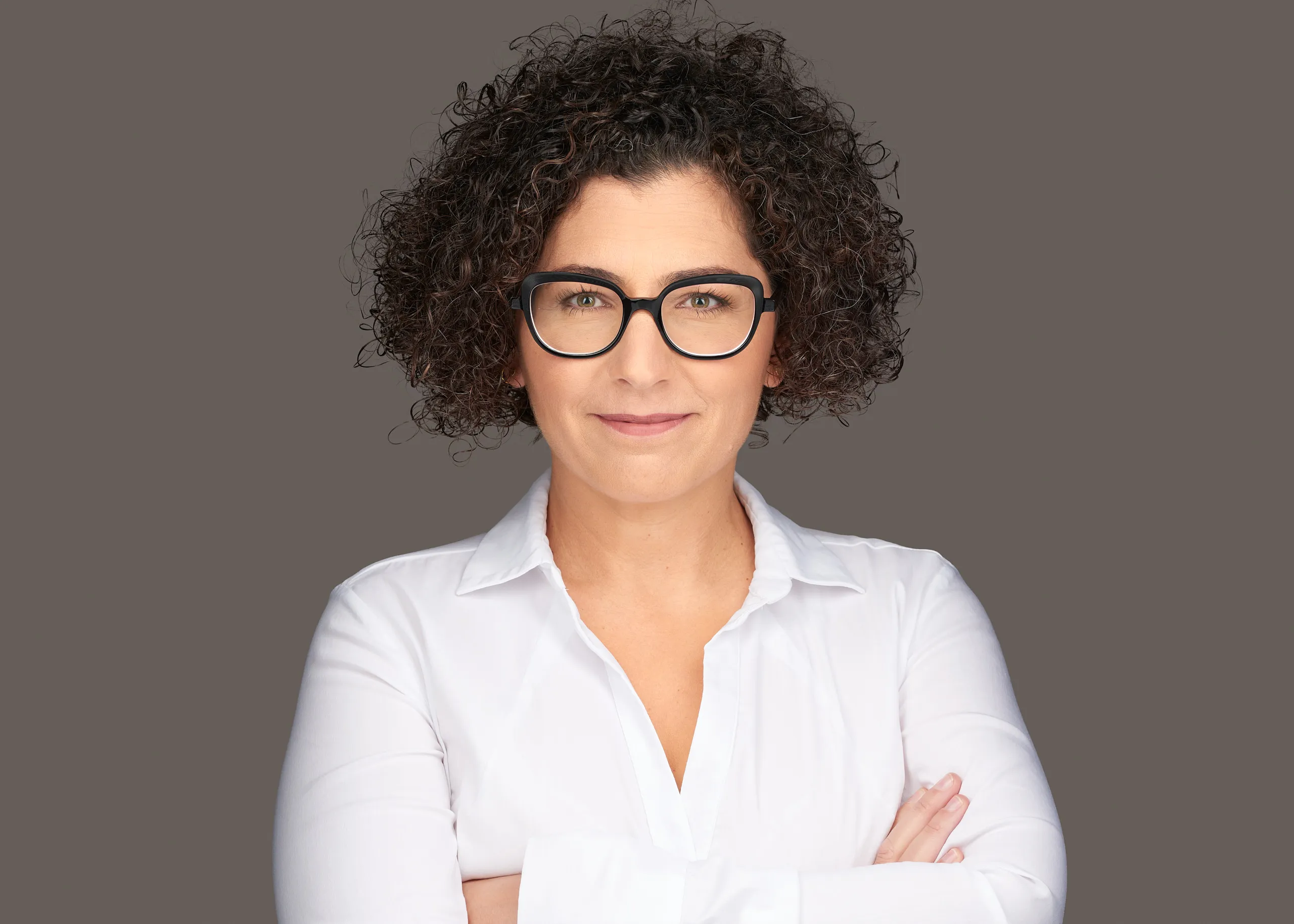 צילום תדמית בסטודיו של אישה עם משקפיים וחולצה לבנה