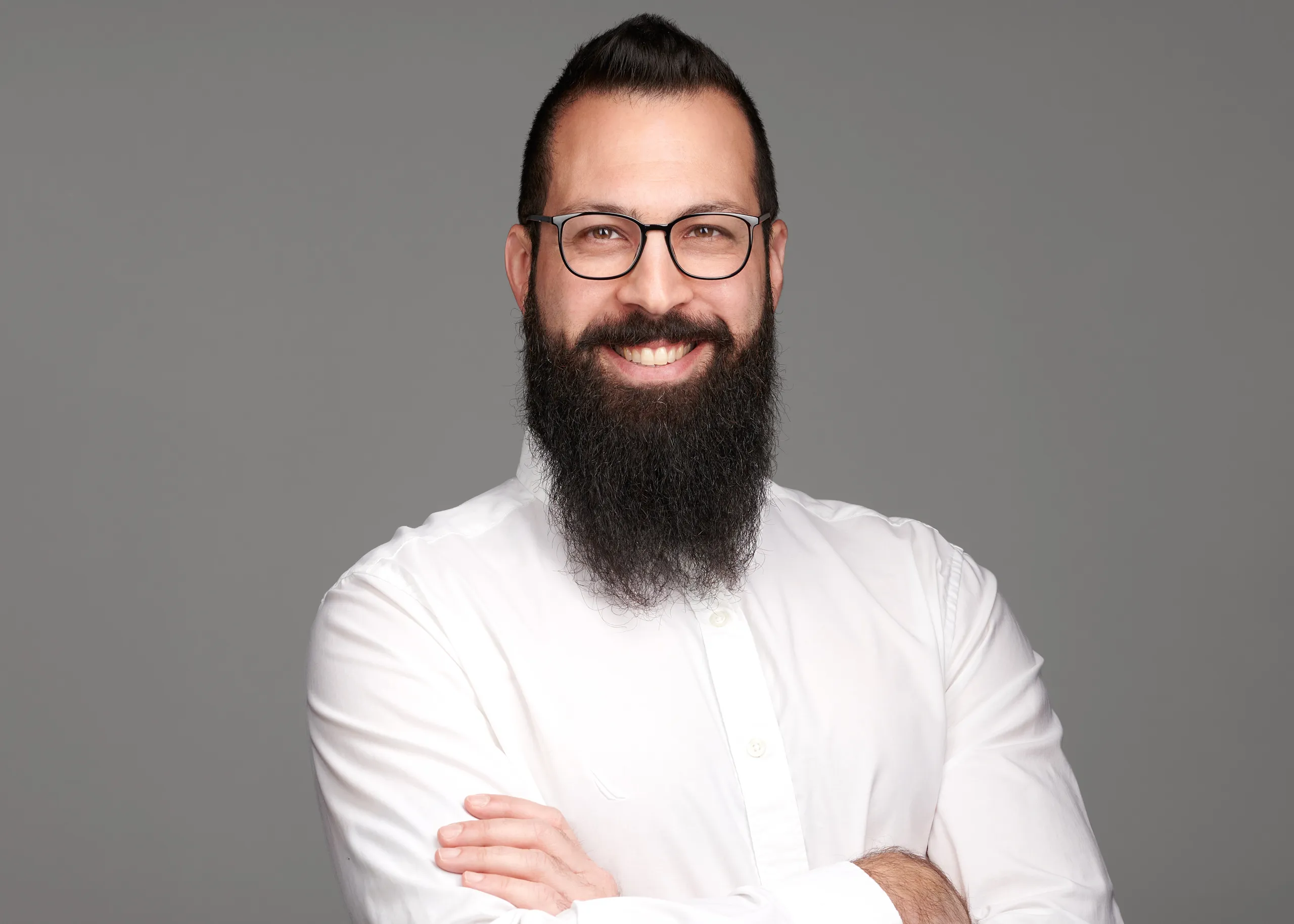 תמונת פרופיל מקצועית של גבר עם זקן ומשקפיים על רקע בהיר