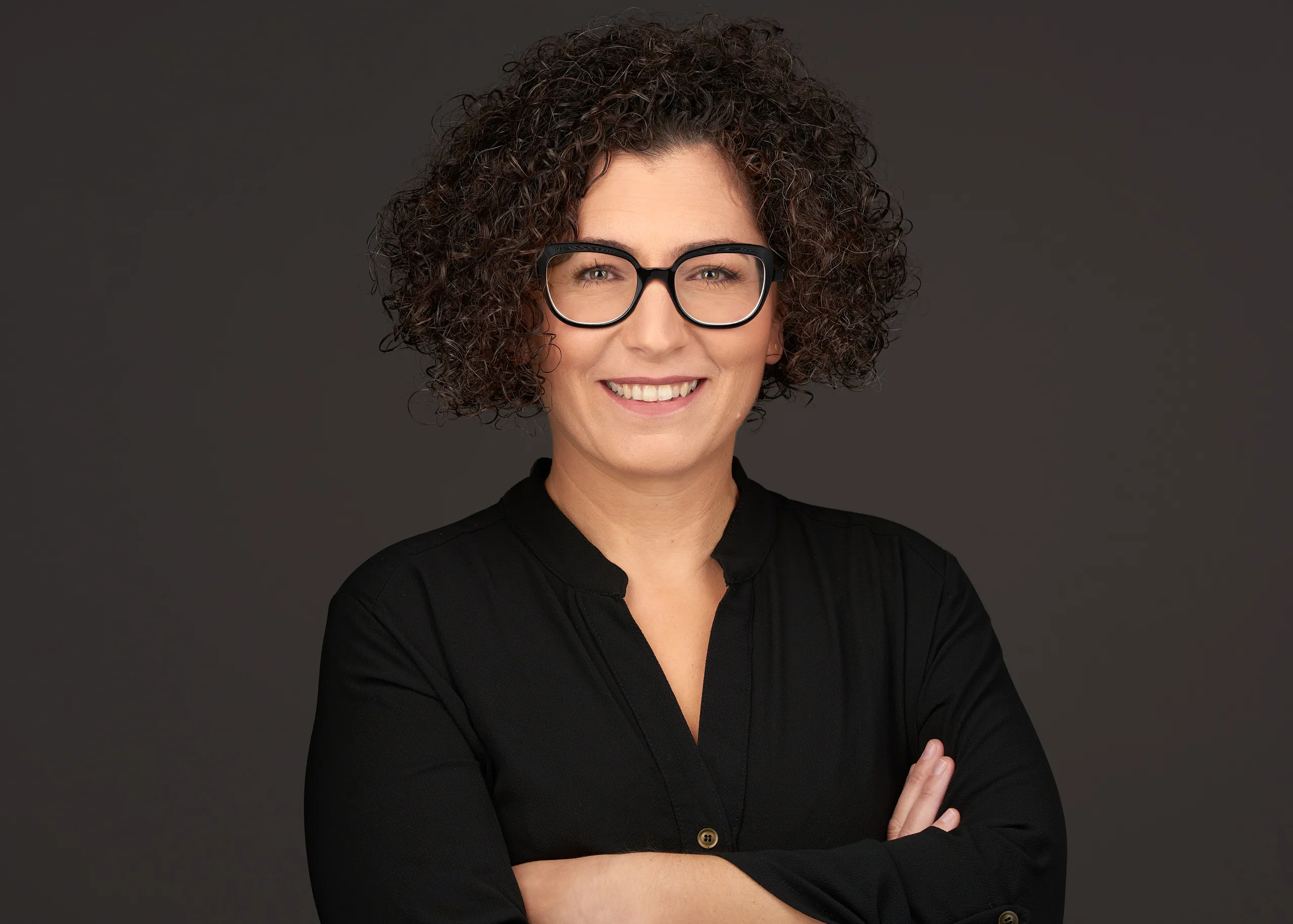 צילום פרופיל מקצועי של אישה עם משקפיים וחולצה שחורה