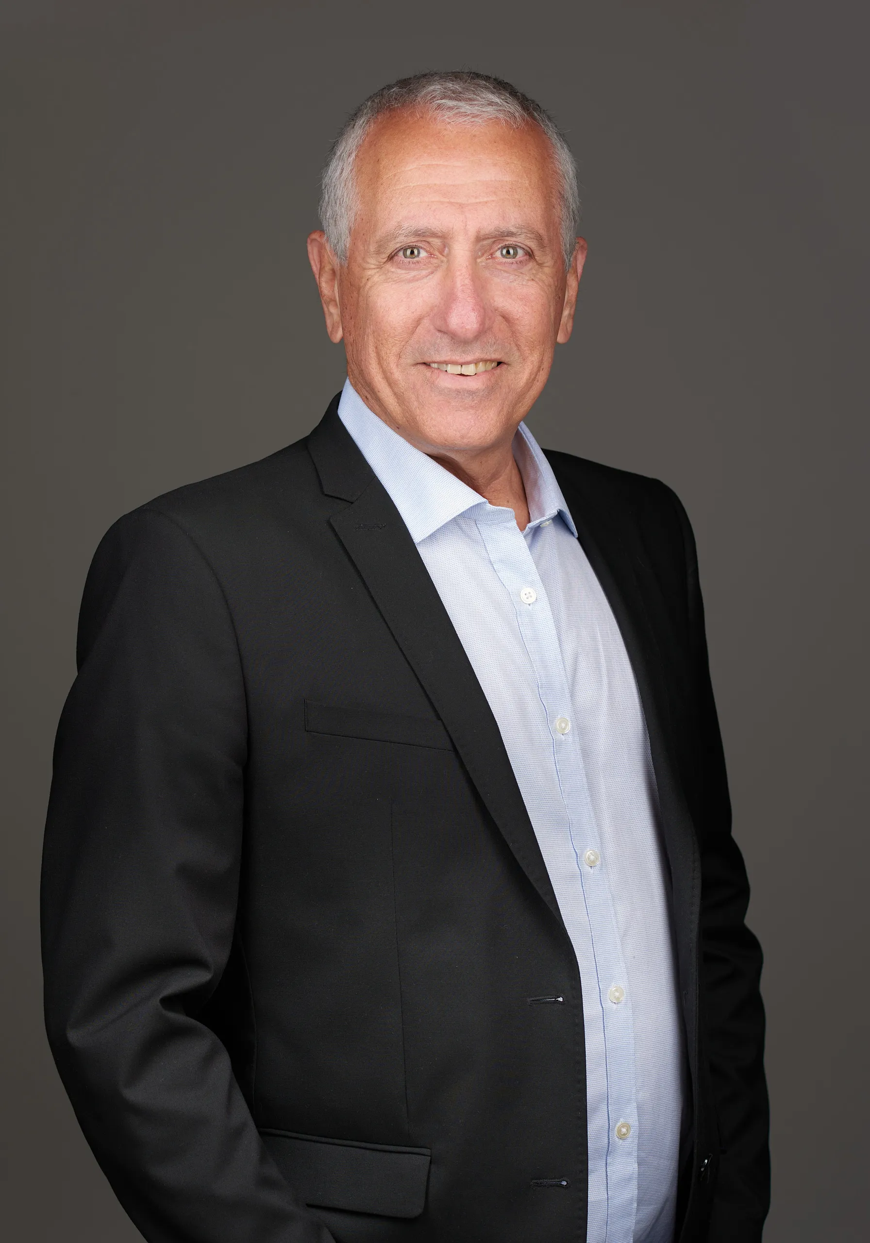 פורטרט עסקי של גבר בחליפה שחורה על רקע כהה לצילום תדמית מקצועי