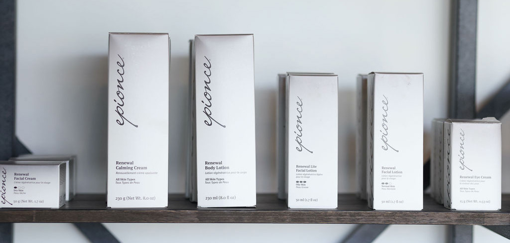 Six Epionce skincare product boxes lined up on a wooden shelf against a light background.