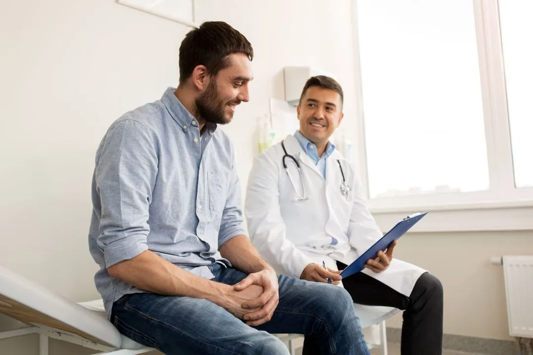 Two men sitting on a bench in a doctors office.