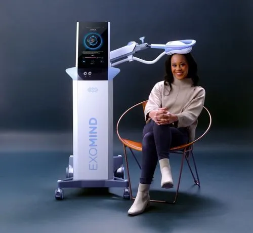 A woman sitting on a chair next to a device.