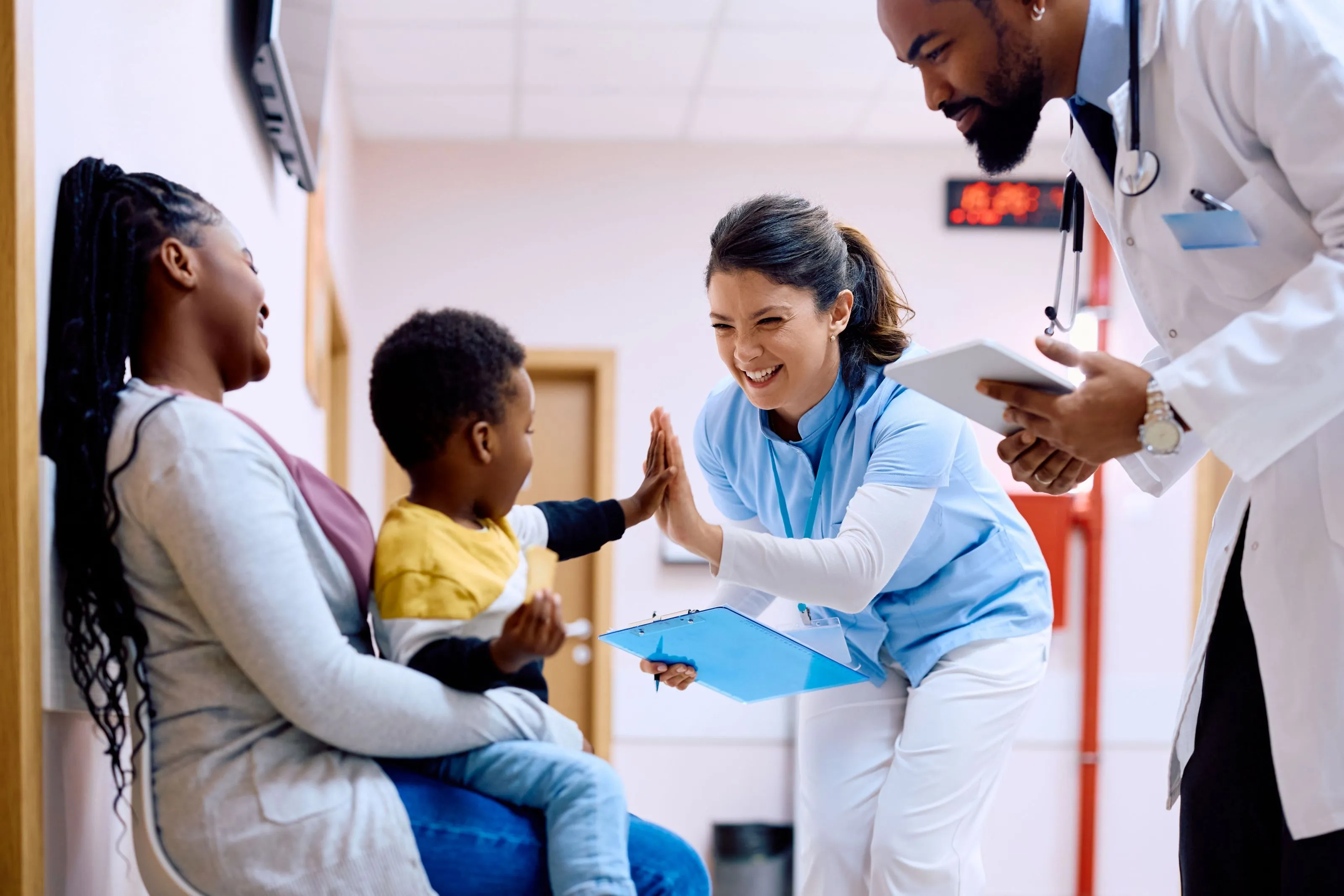 A doctor giving a high five to a child.