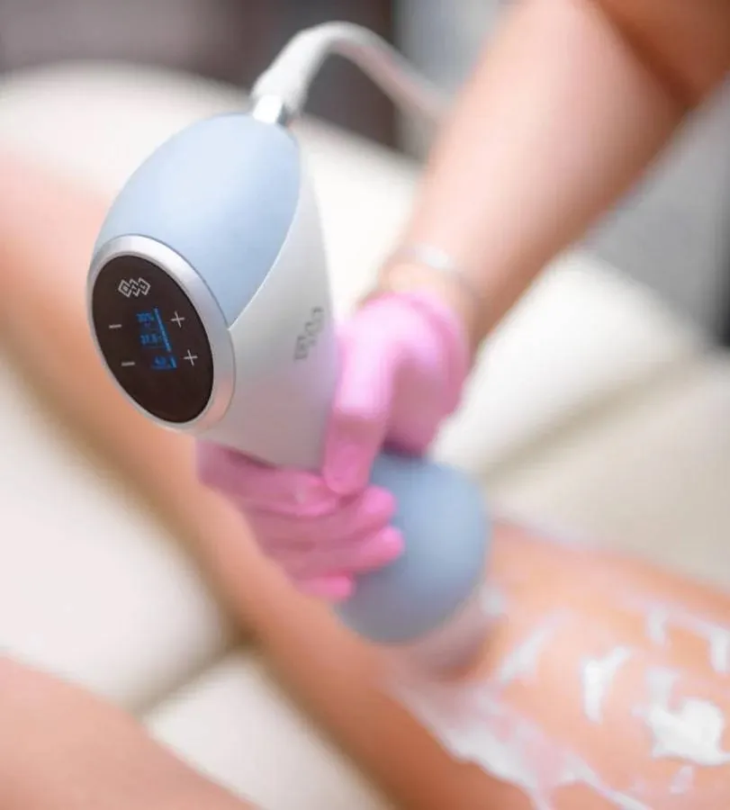 A woman is using a BTL EmTone on her body.