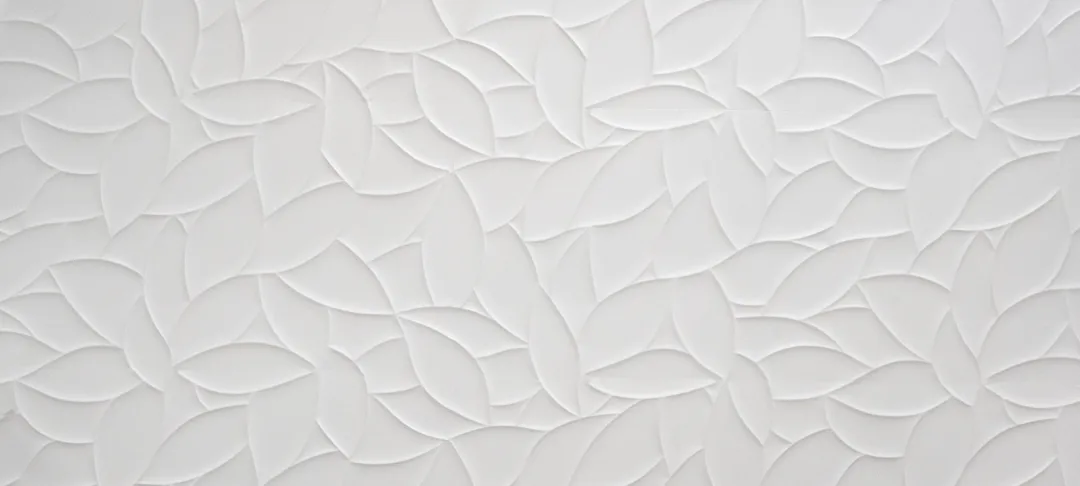 A close up of a white wall with a pattern on it.