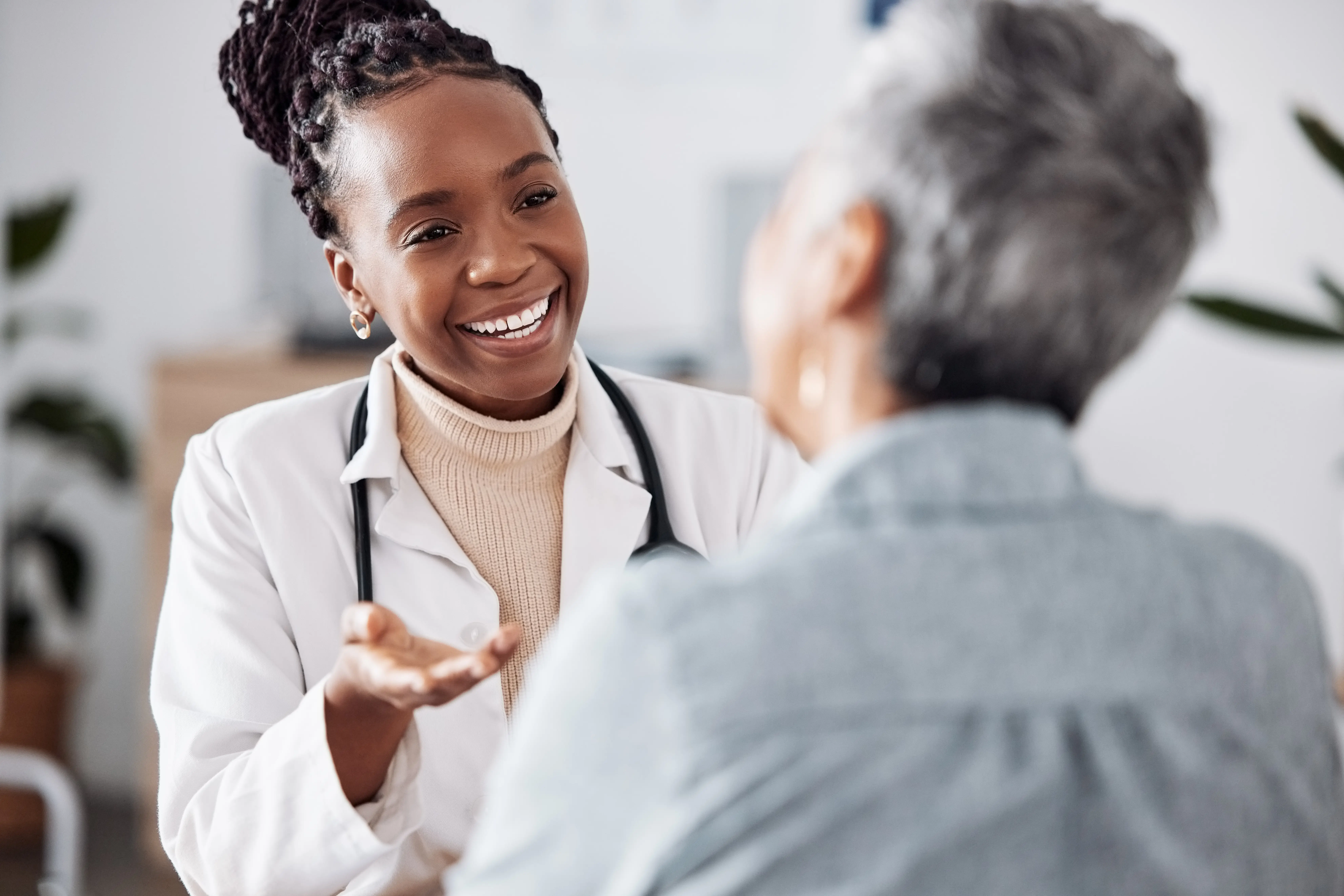 black female doctor talking with female patient