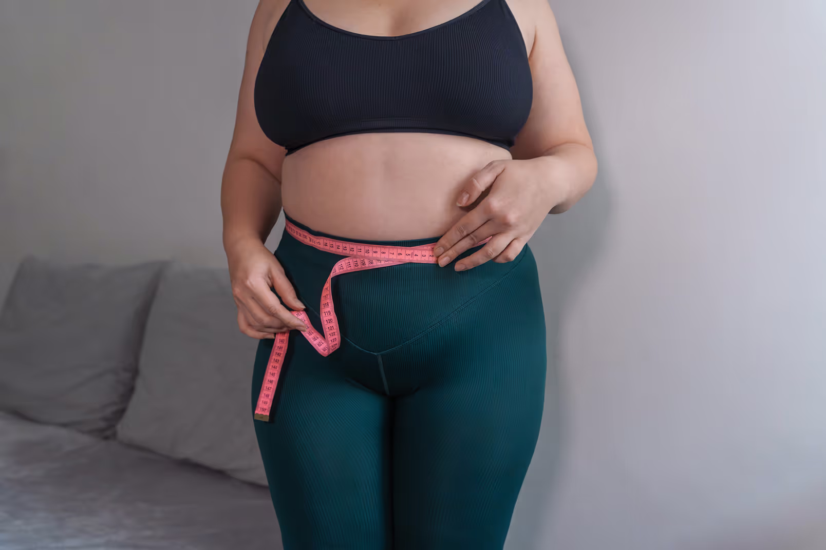 A woman measuring her waist