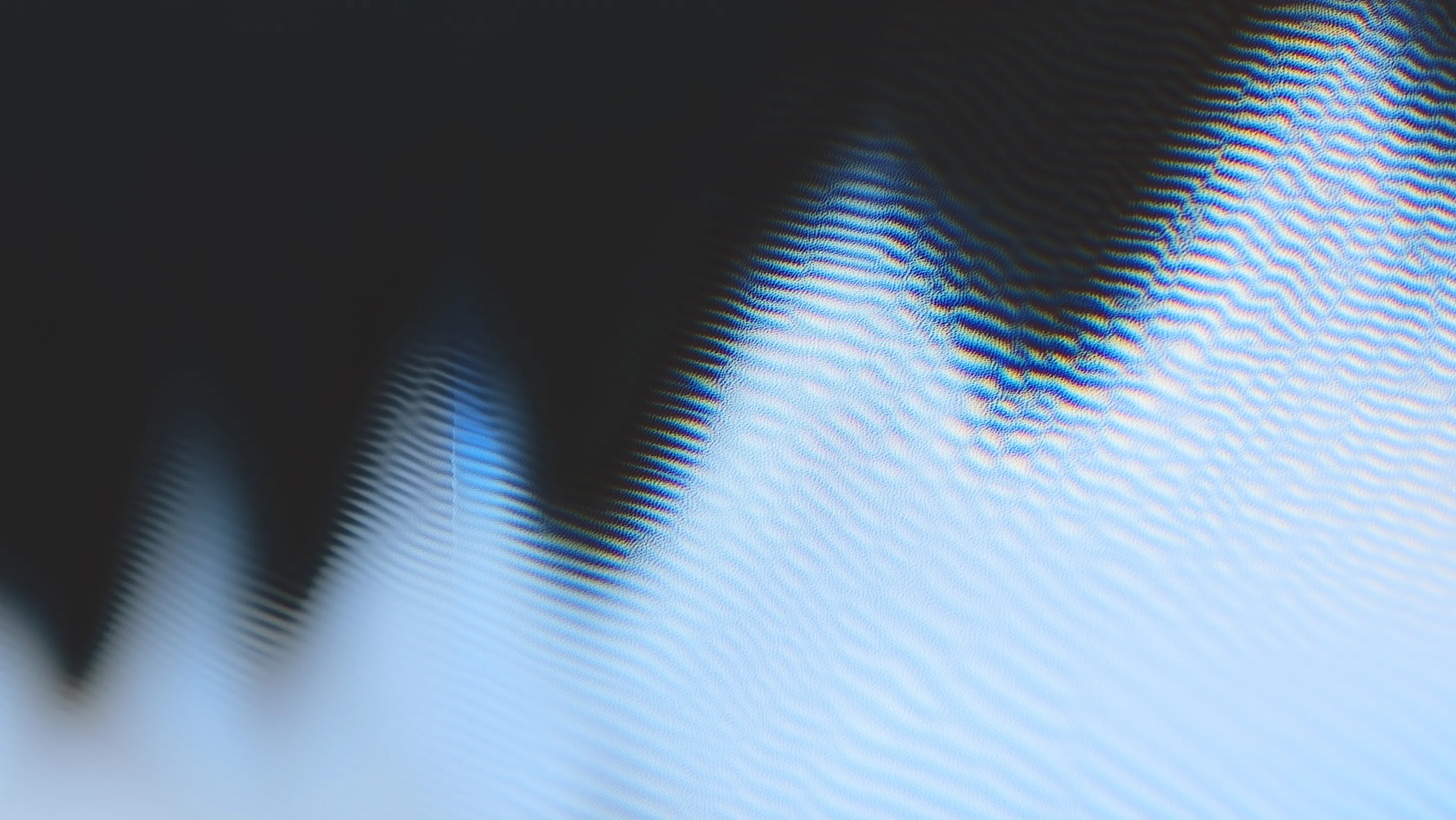 Close-up of a digital screen displaying a wavy, distorted blue and black pattern with visible pixel interference.