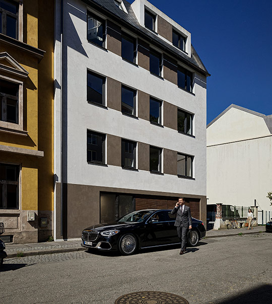 Hand placing a white golf ball on a tee over green grass on a golf course.