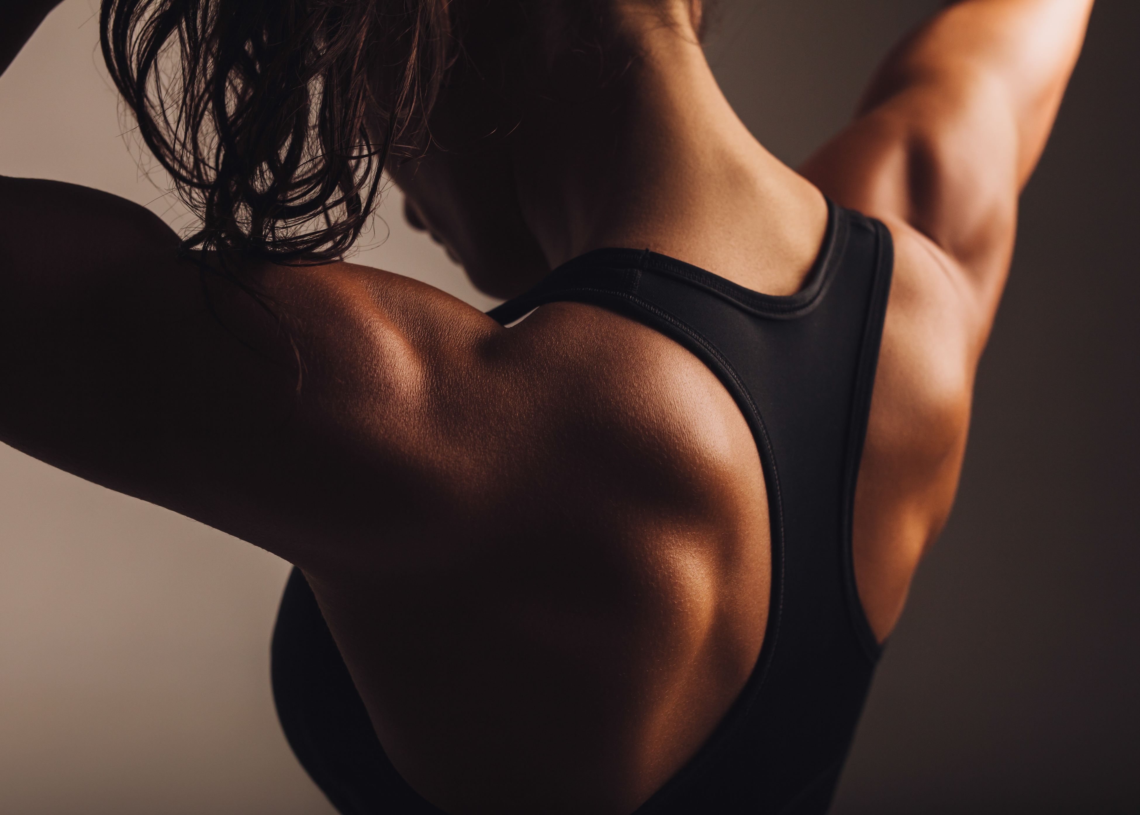 woman's back wearing black sports bra
