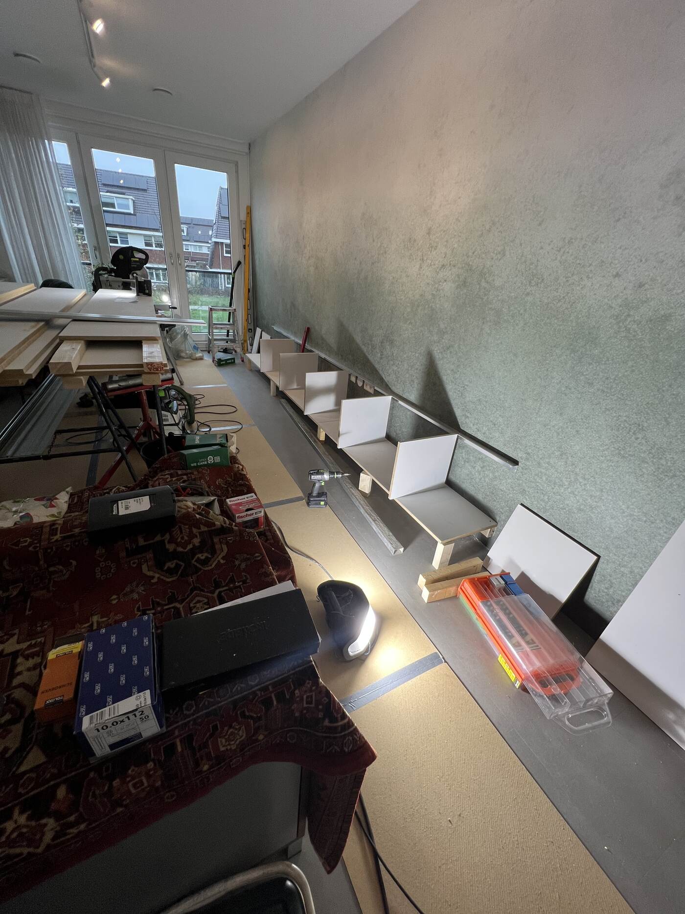 Start van de montage: de eerste kastdelen staan klaar tegen de wand