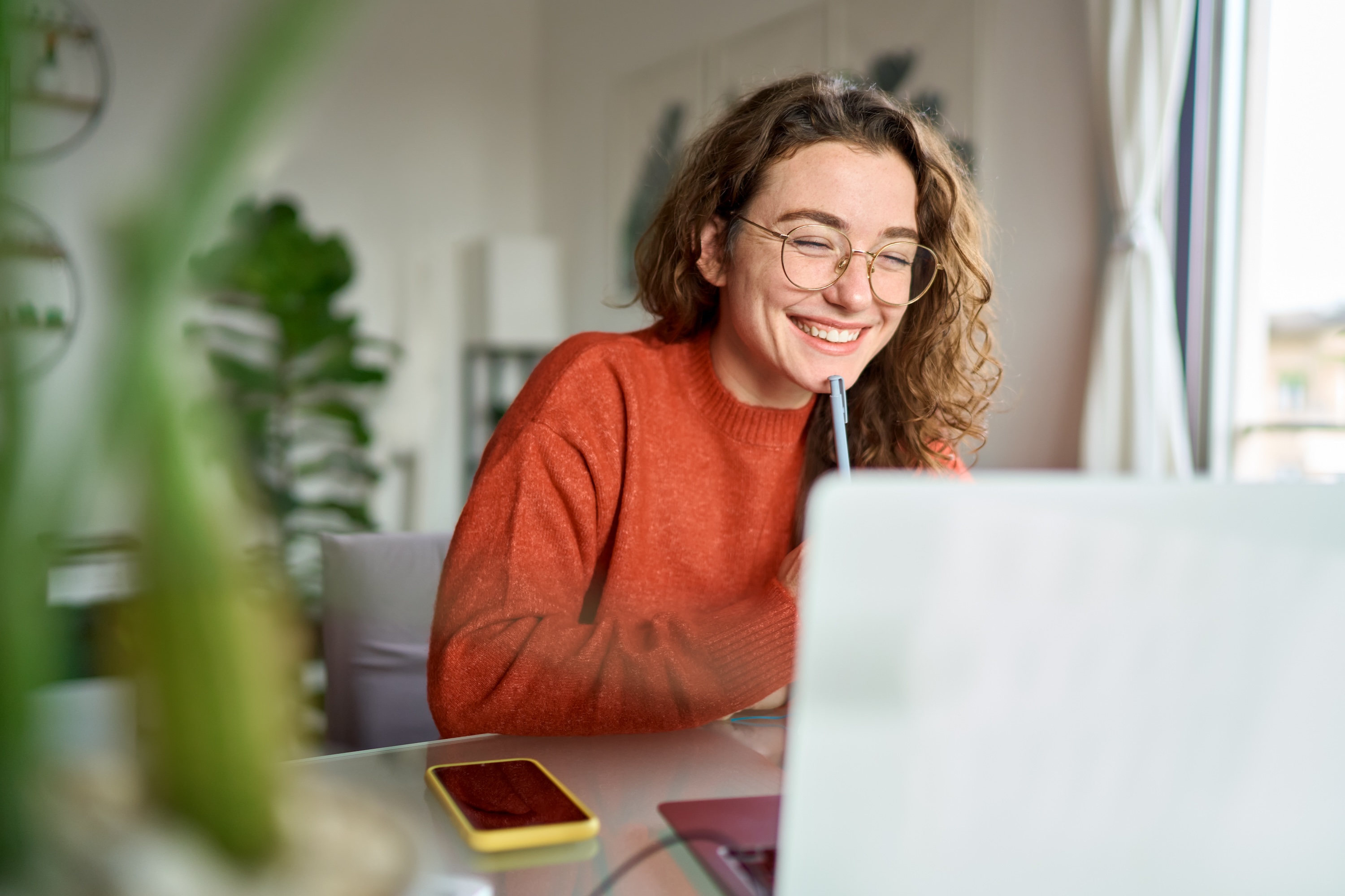 Resident smiling at a laptop in a bright home office at Adora at Rosehill, Tomball