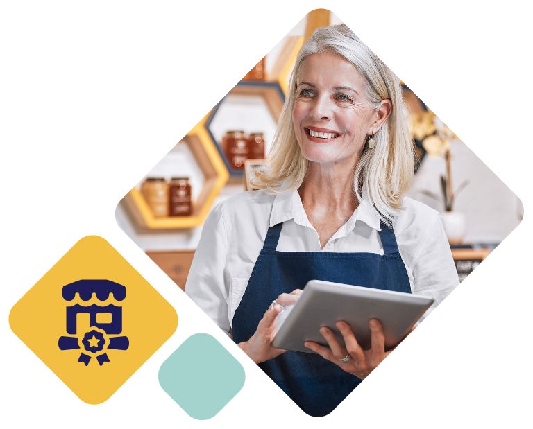 Female business owner holding an ipad and wearing an apron in front of her honey
