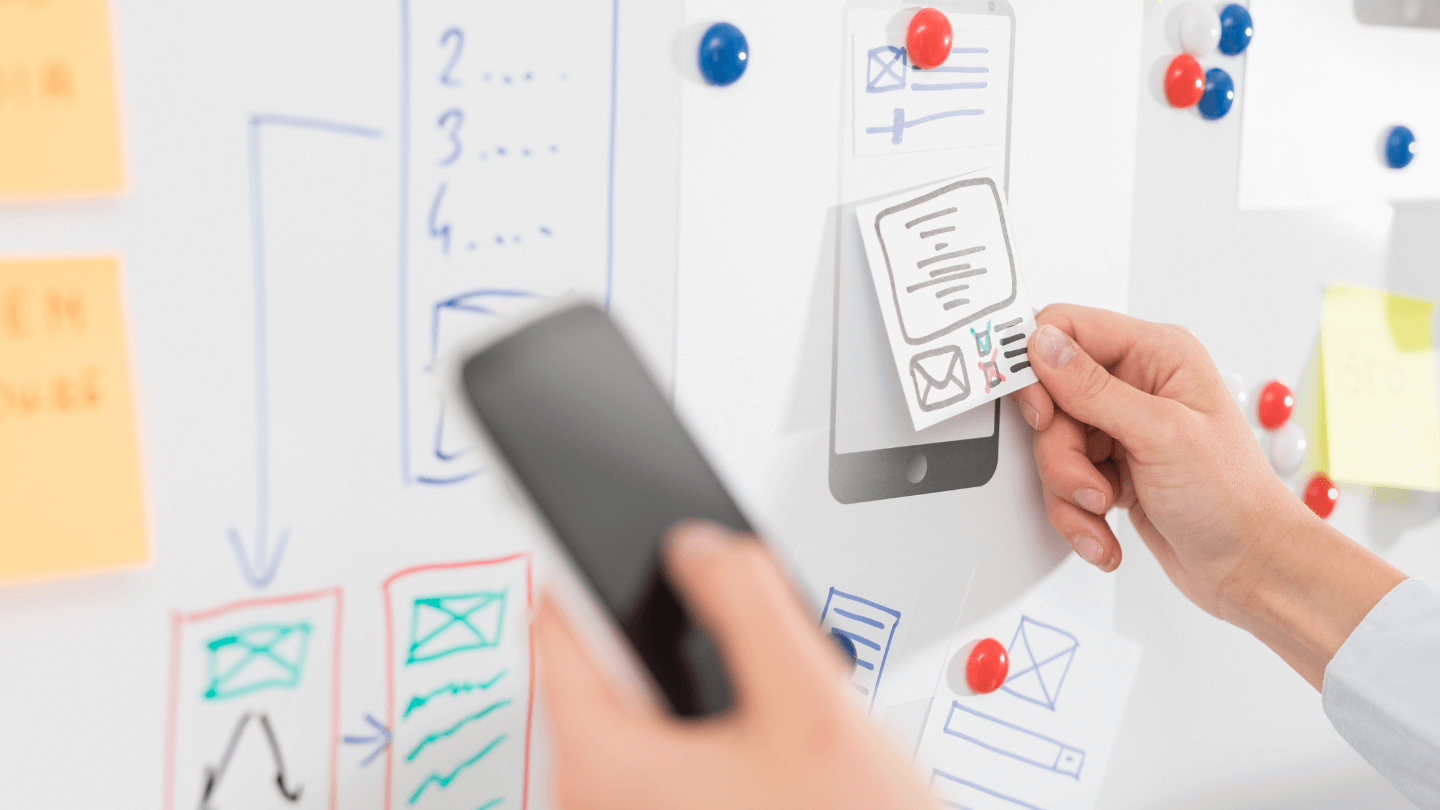 A human hand working on some frameworks while holding a phone
