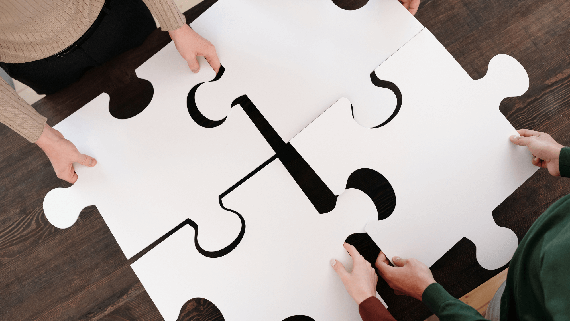 Pieces of a puzzle putting together by a group of people
