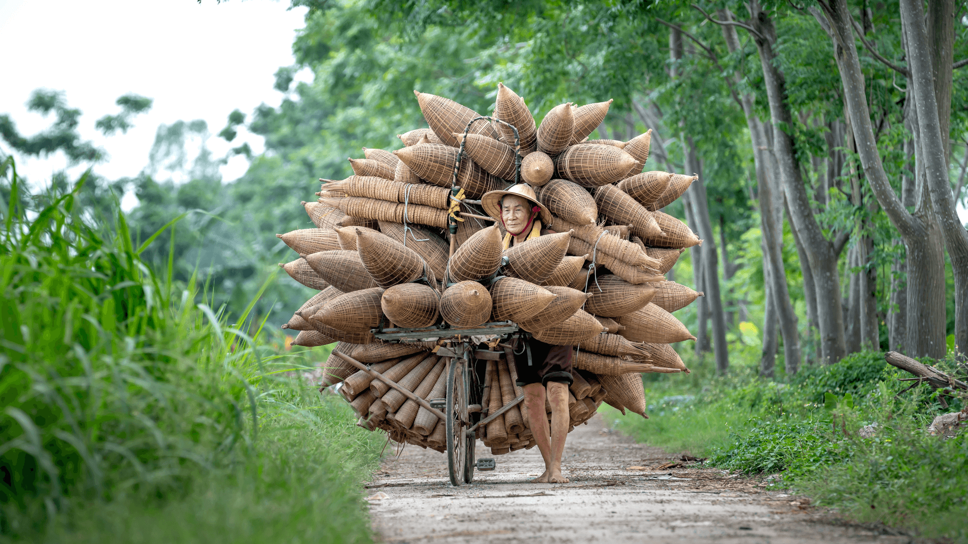 A person pushing a bicycle while carrying heavy things