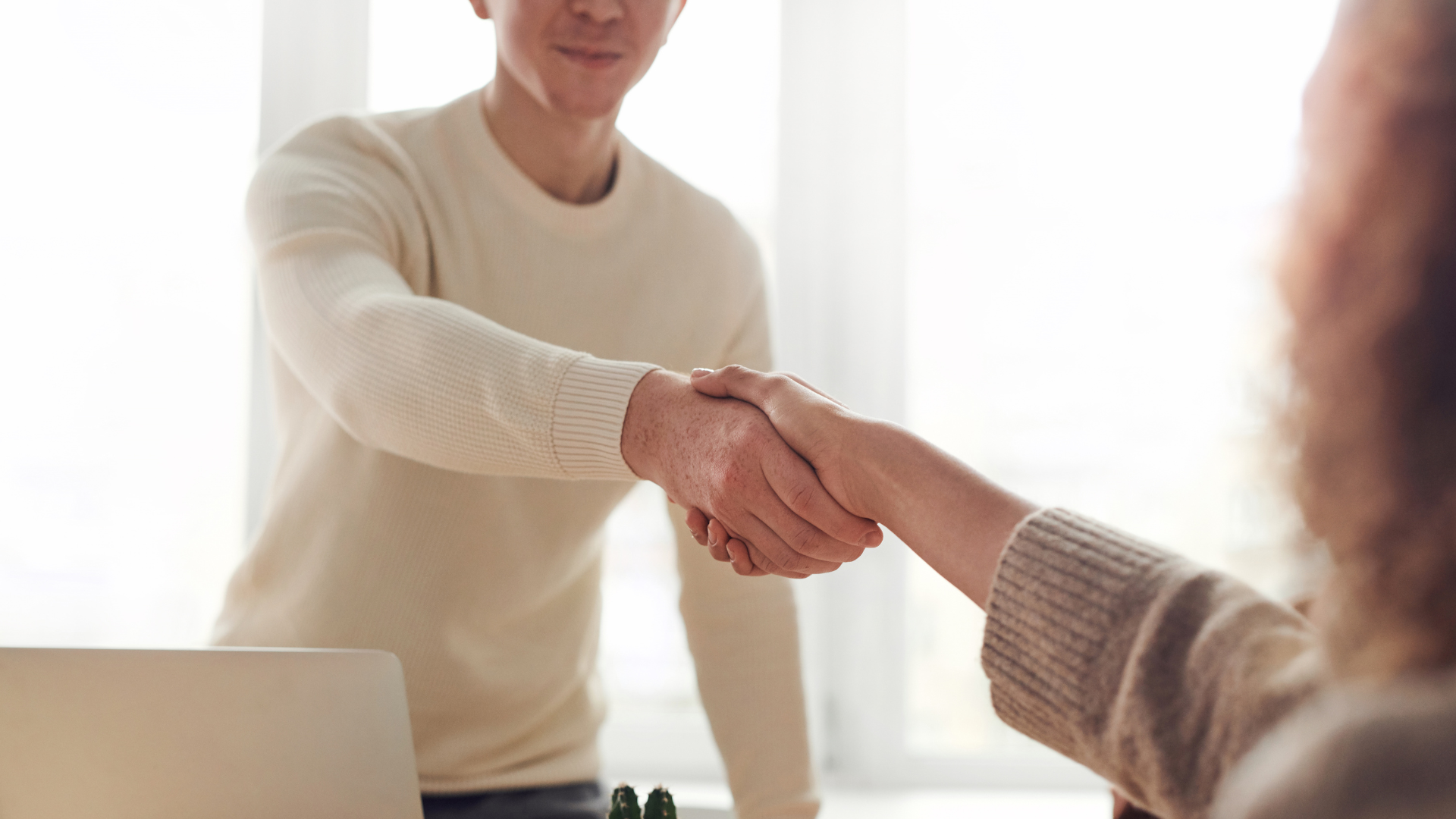 Two people shaking hands showing a sign of agreement over something