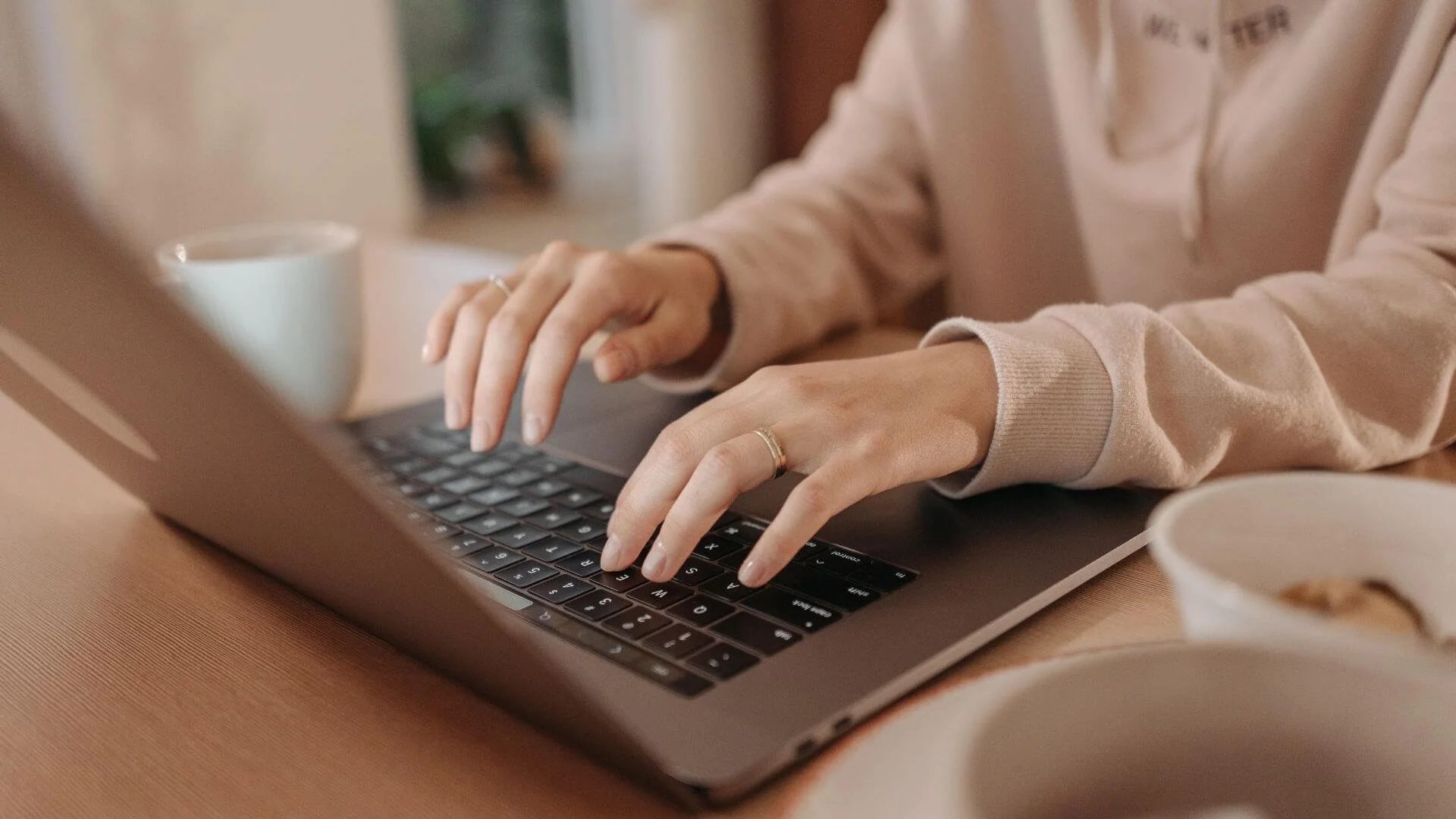 Woman typing on a laptop's keyboard